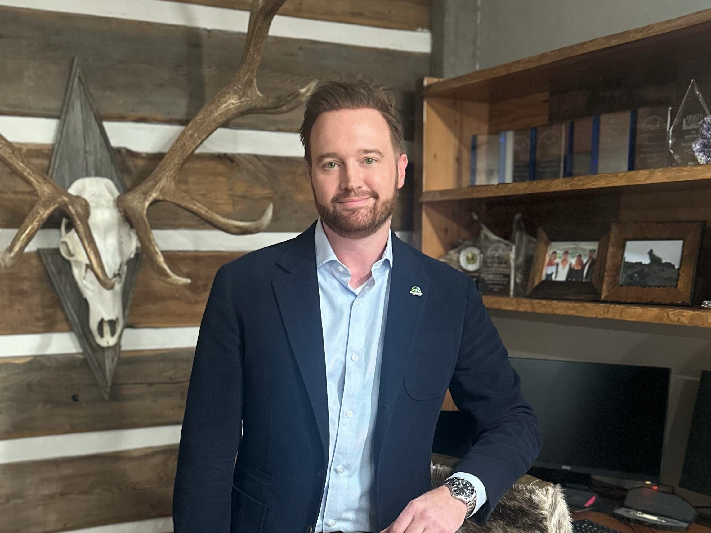 a man poses for a photo in his office