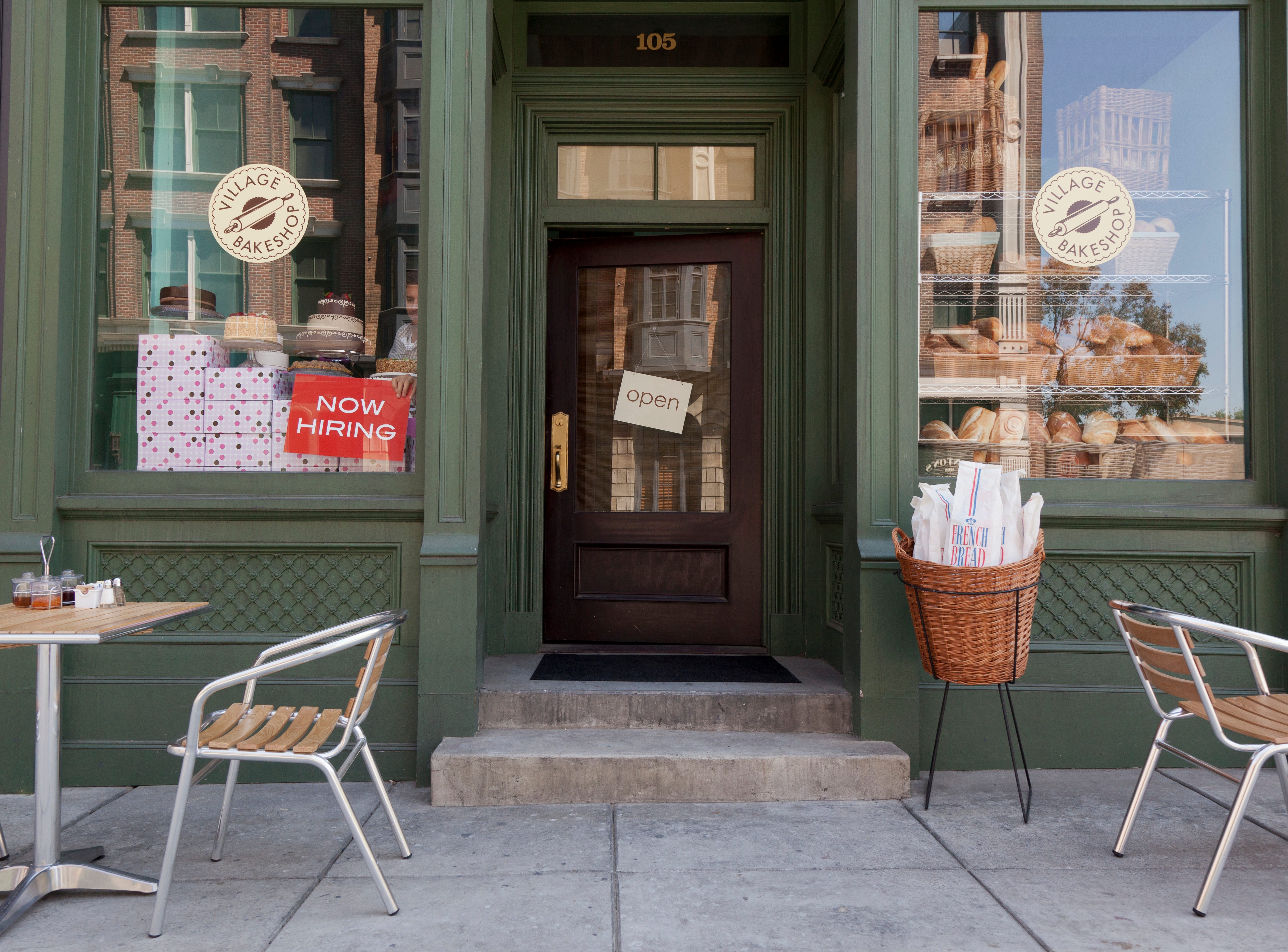 A cafe with a "now hiring" sign in the window.