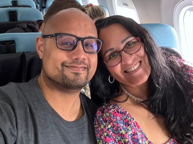 Author Kimanzi Constable smiling on plane with wife