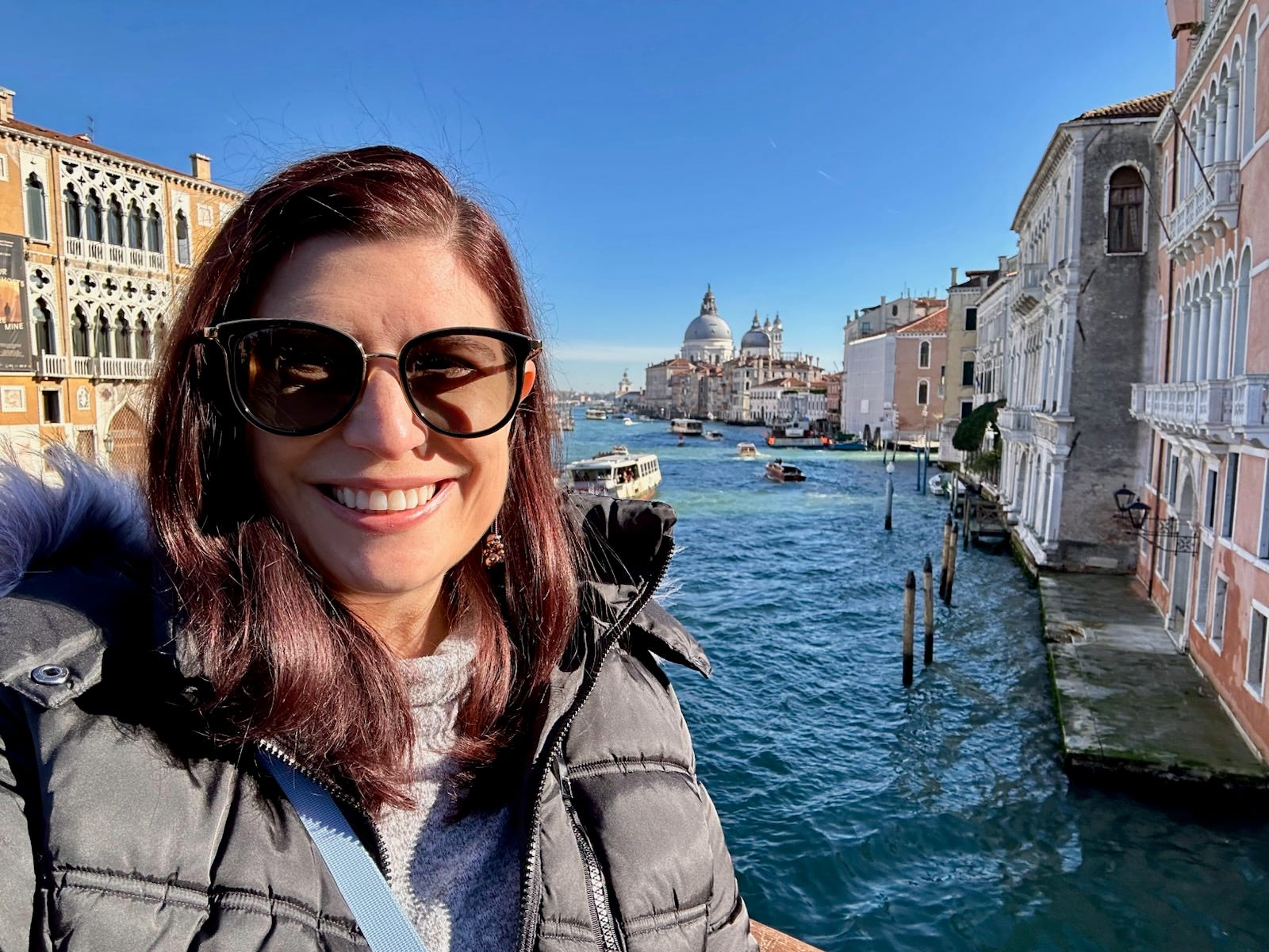 Author Amanda Adler smiling in venice canal with sunglasses on