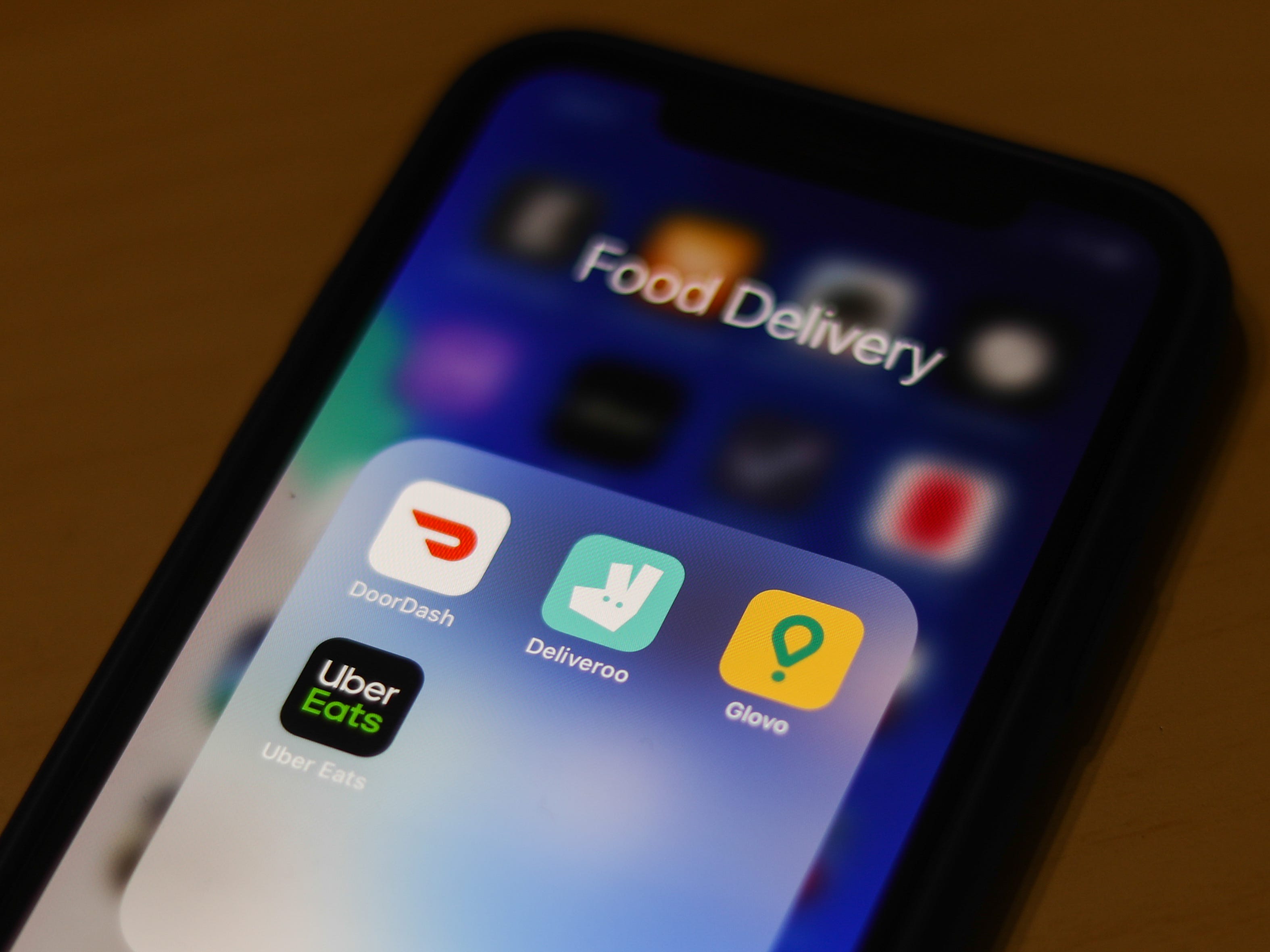 a phone with food delivery apps opened like door dash and uber eats