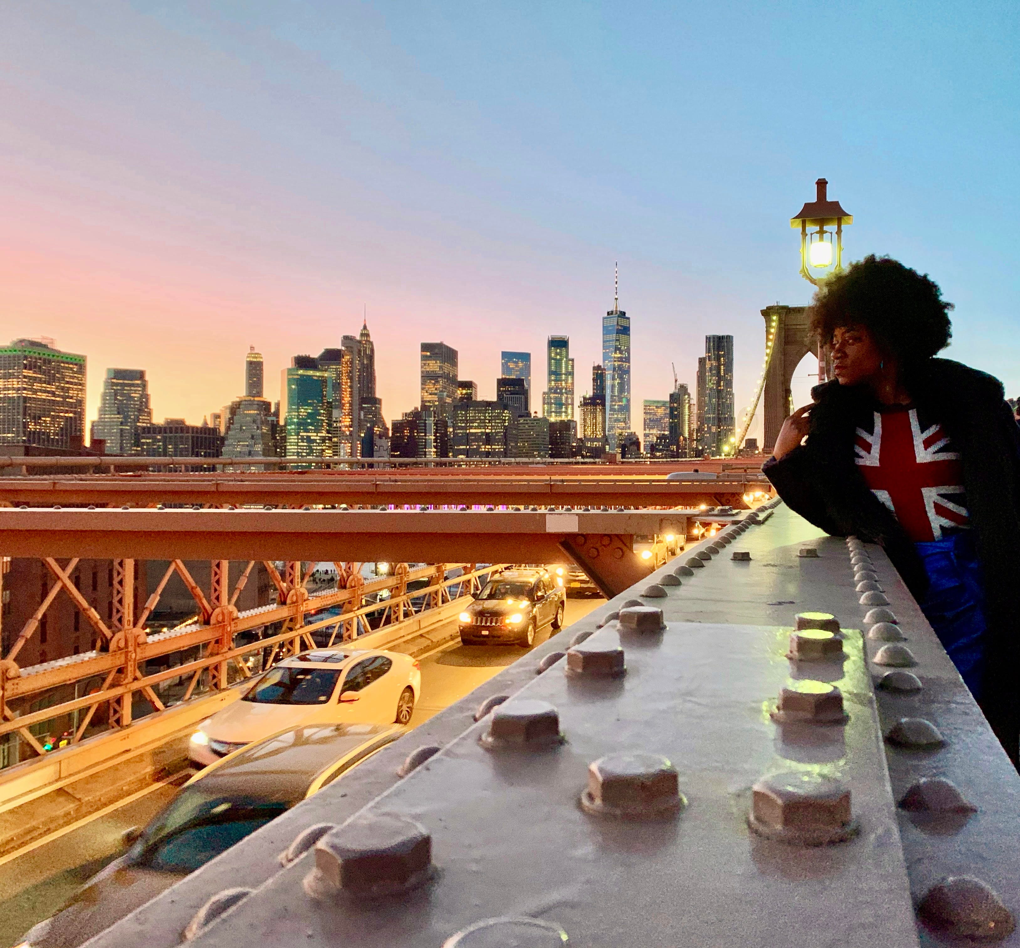 person looking over busy street with new york city skyline in background