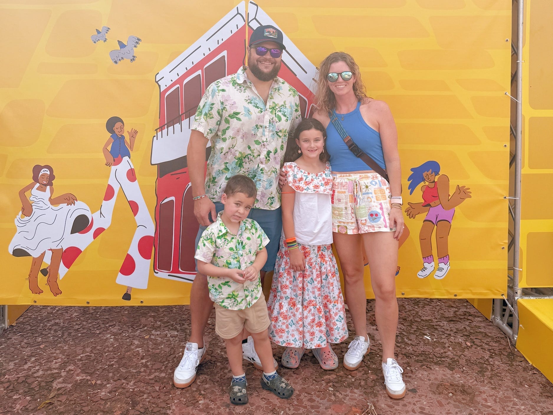 A family of four posing for a picture in front of a sign in Spanish.