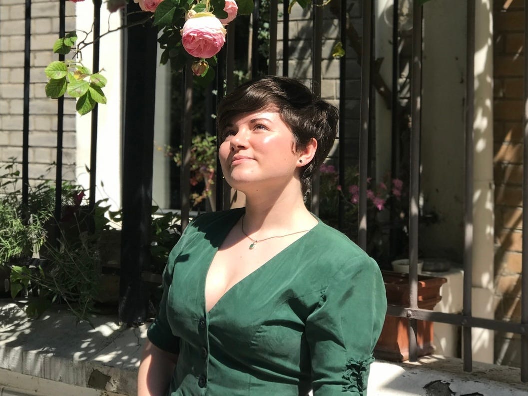 The author looking up and smiling. She's wearing a green V-neck top.