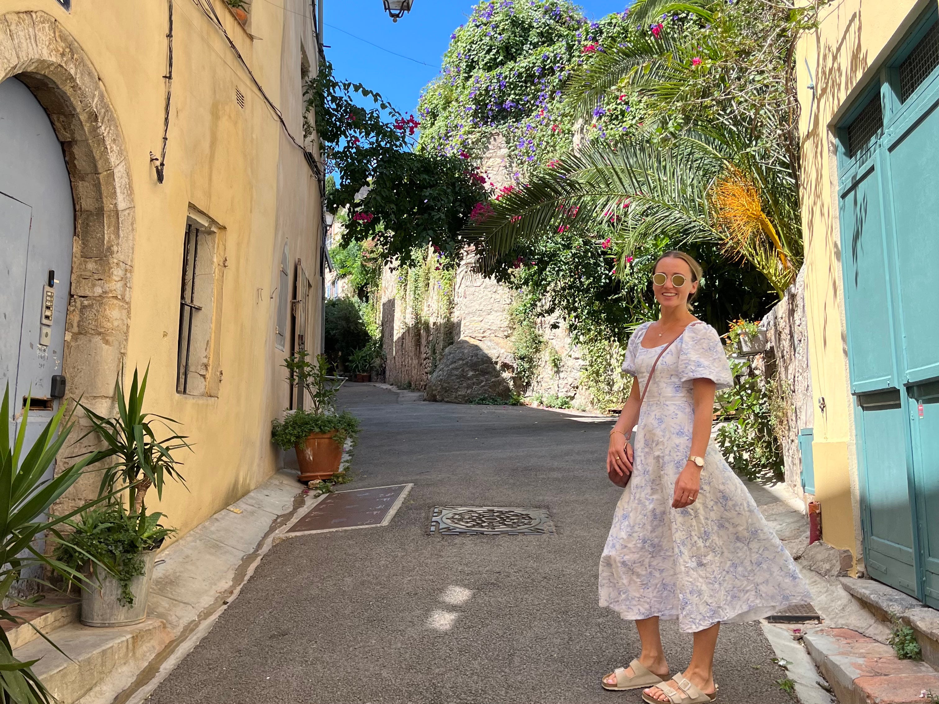 woman in white and blue dress on narrow street in Hyères