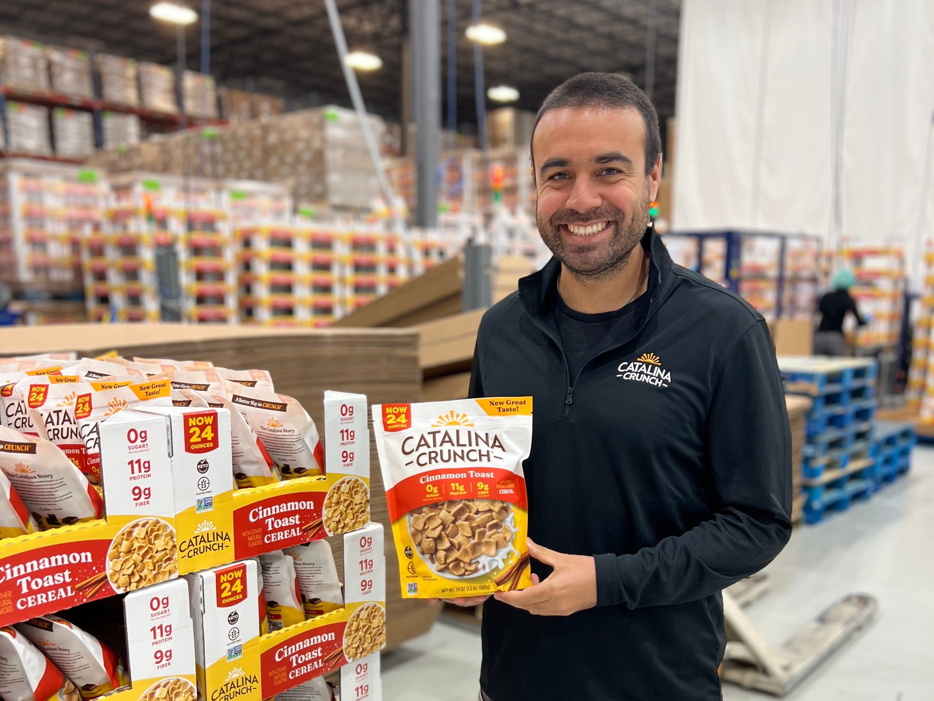 Krishna Kaliannan smiles as he holds a pack of Catalina Crunch