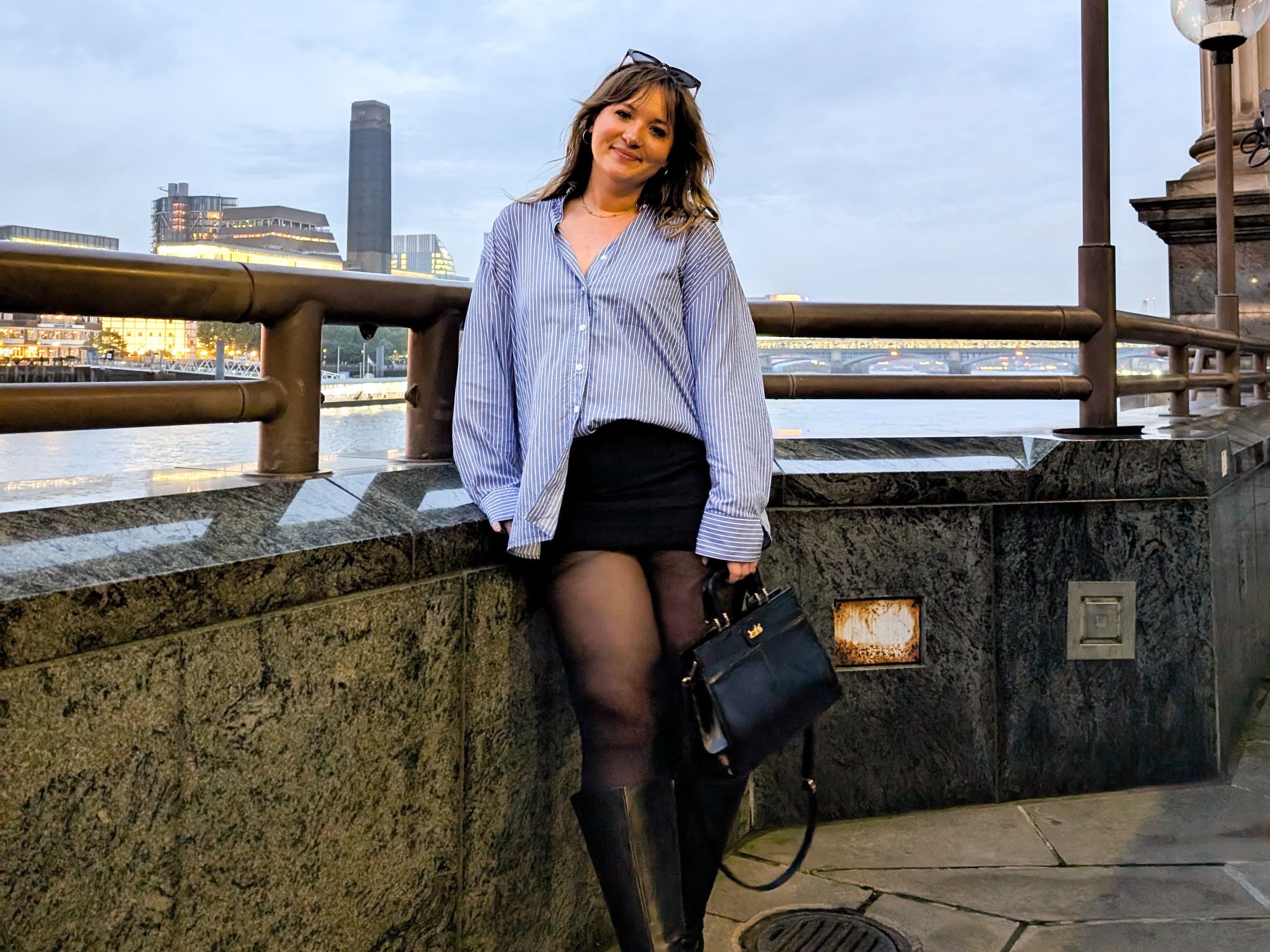 Fleurine poses in front of a viewpoint by a river.