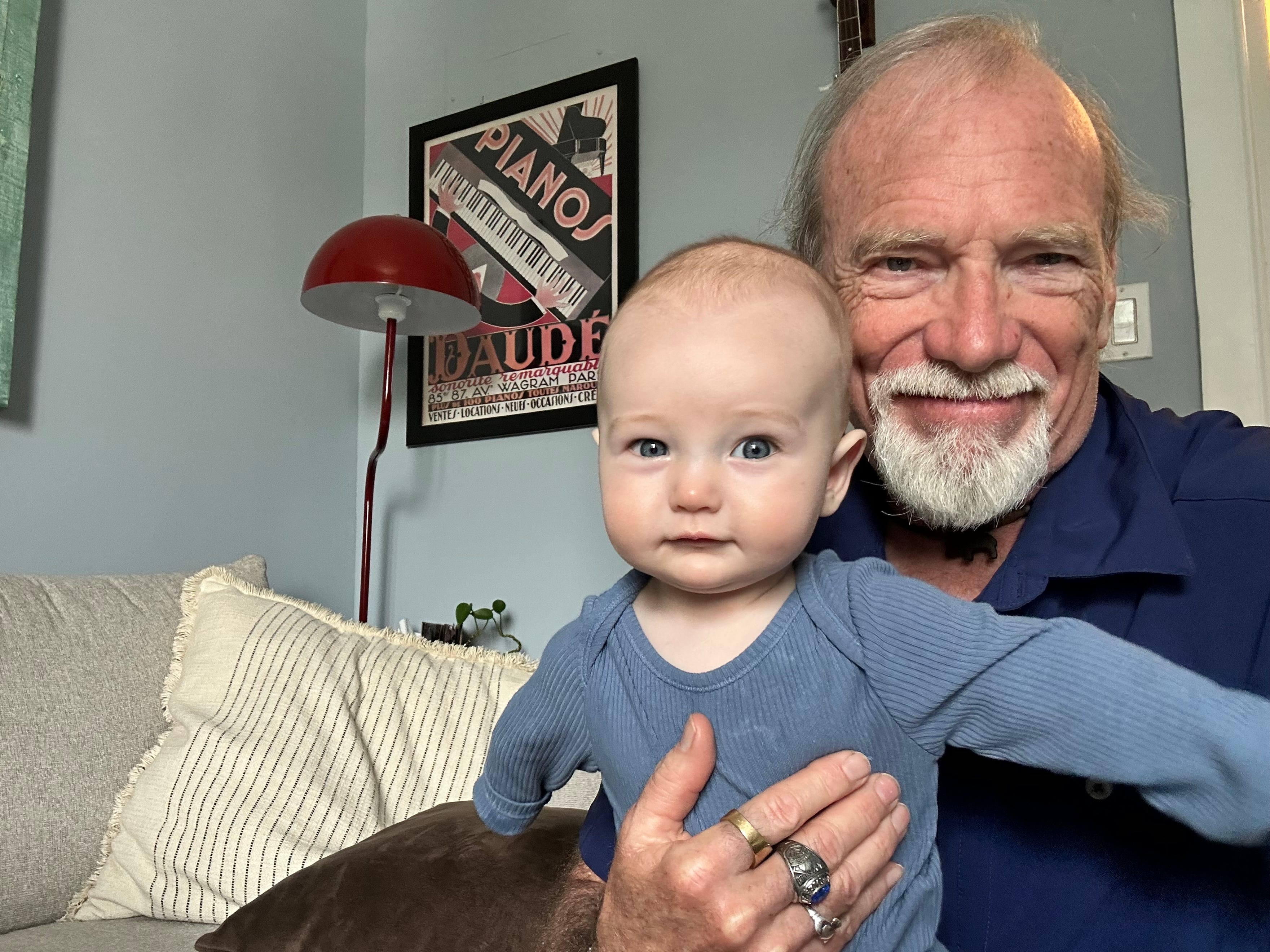 Steve smiles while holding his young grandson.
