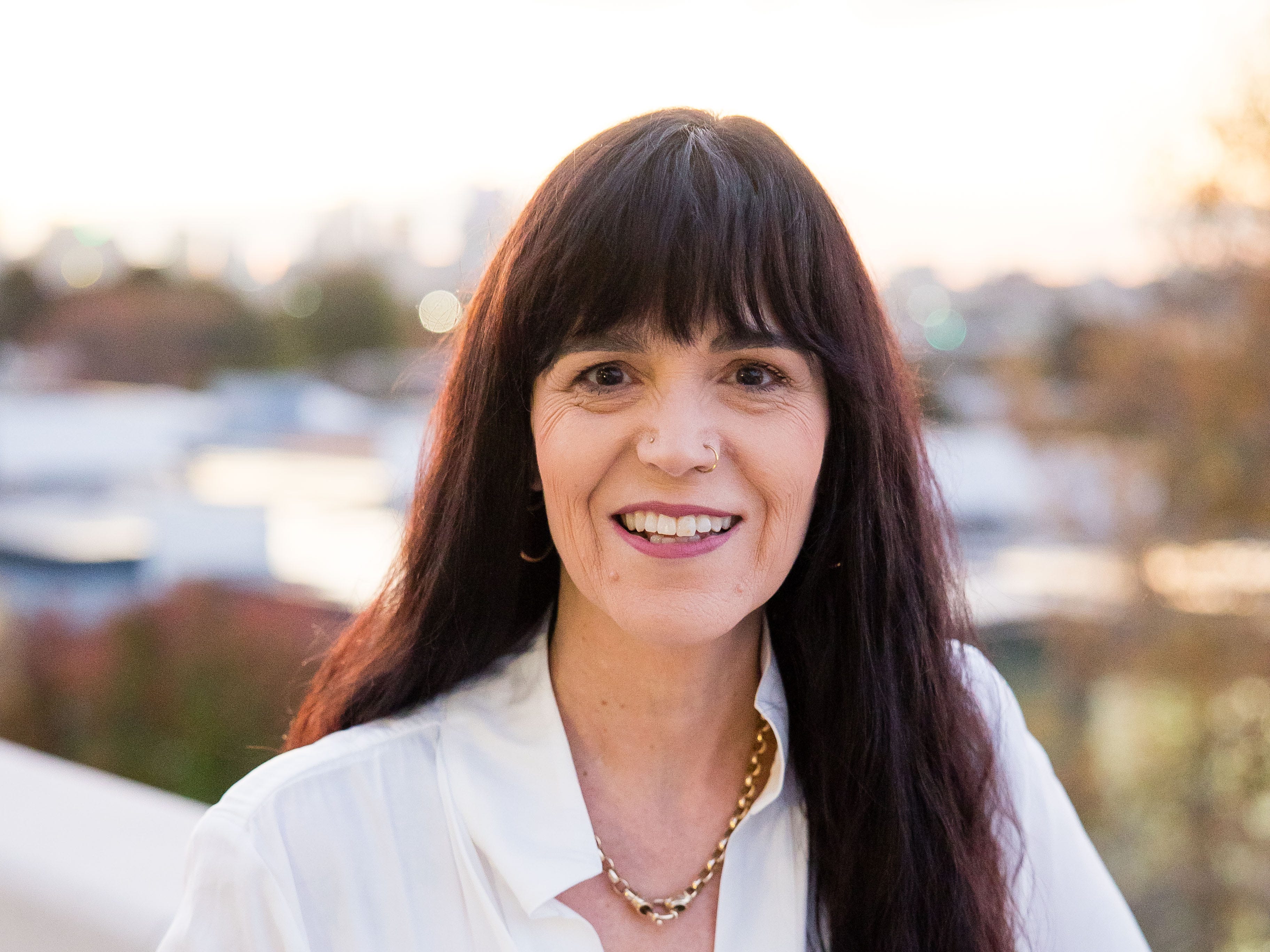 Justine Martin standing on a balcony and smiling.