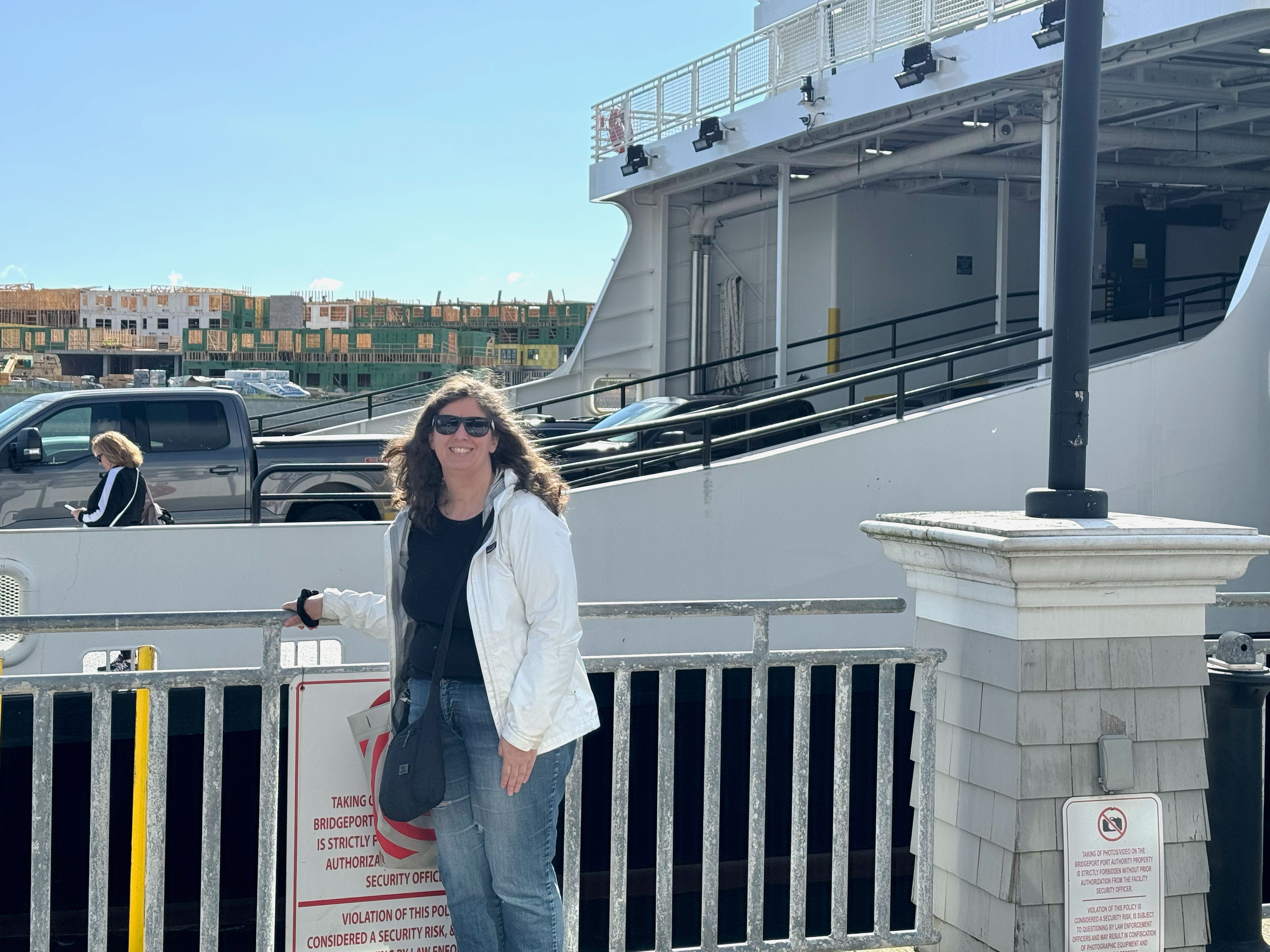 Michele poses for a photo in front of a large ferry.