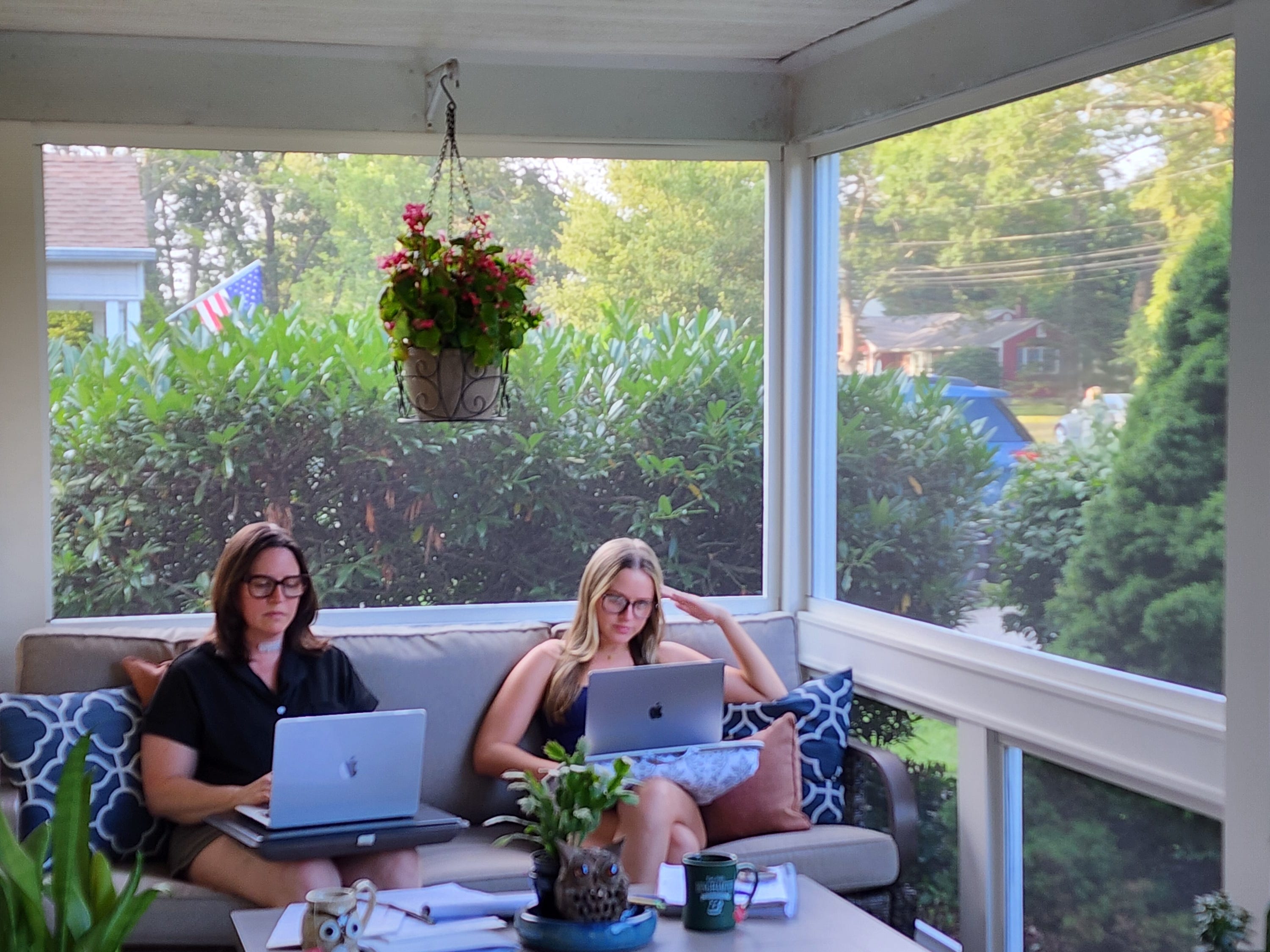Jennifer Young and her daughter sitting on a couch working