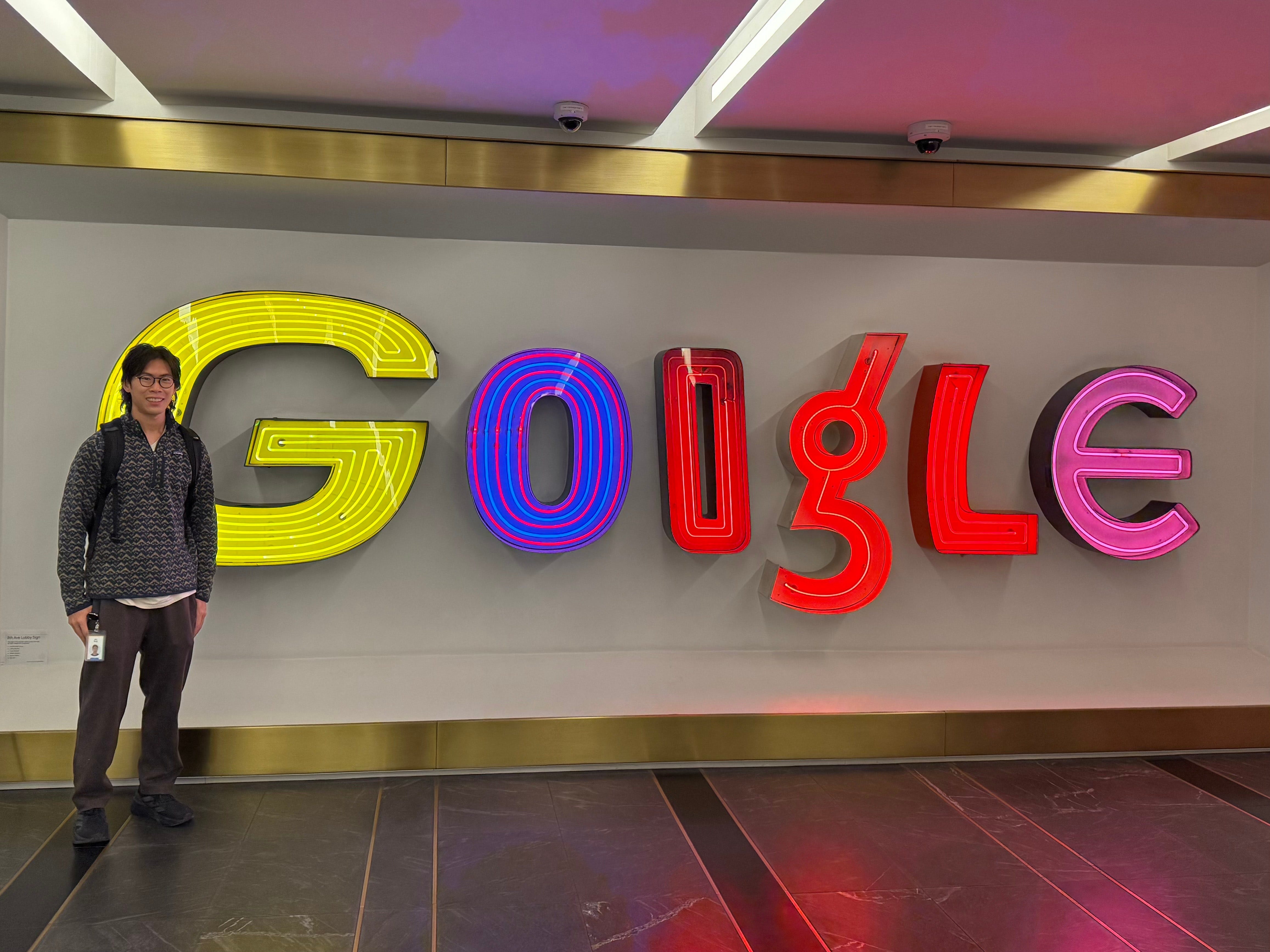 Jim Tang standing in front of the Google sign at one of Google's offices.