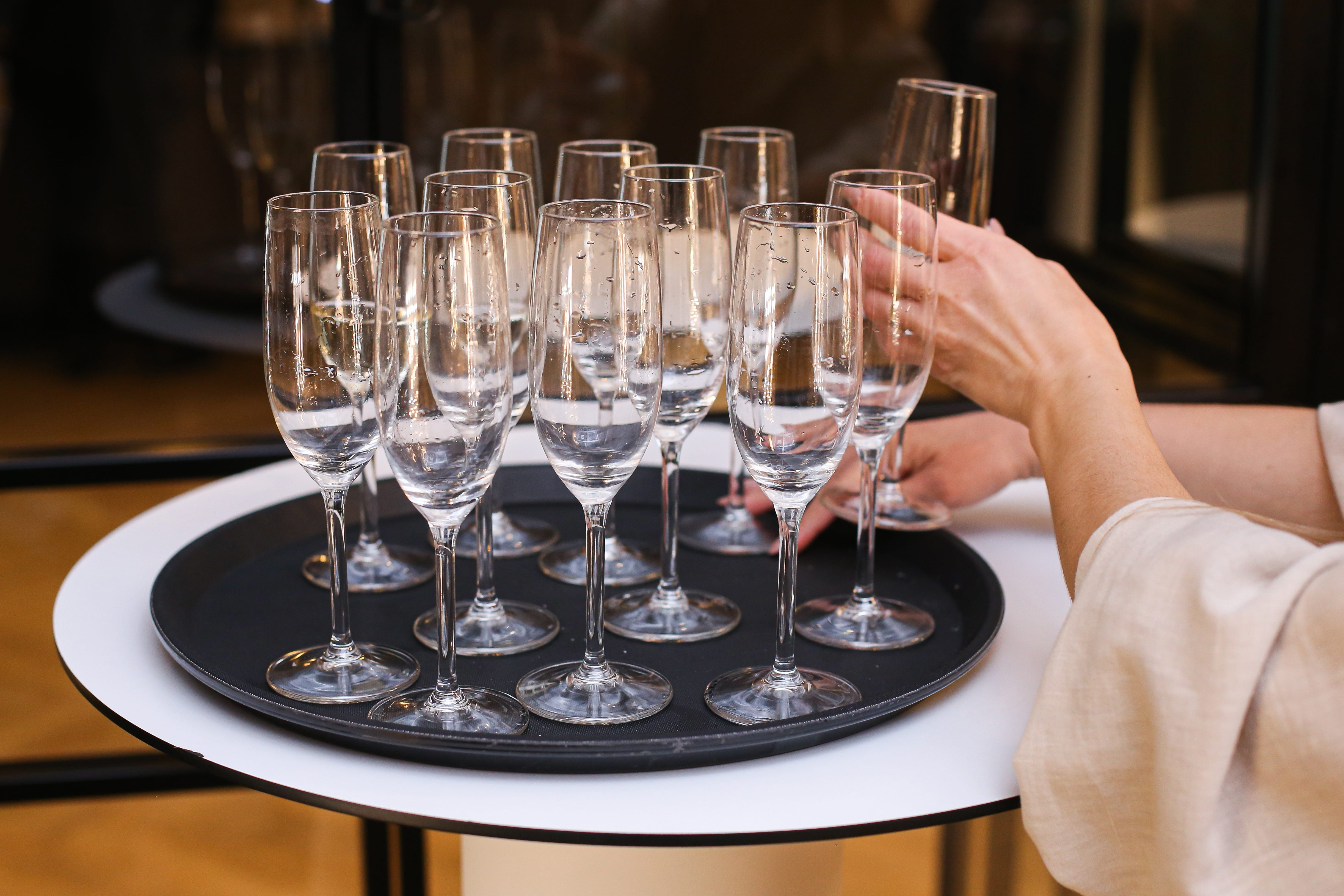 People grabbing Champagne glases from tray