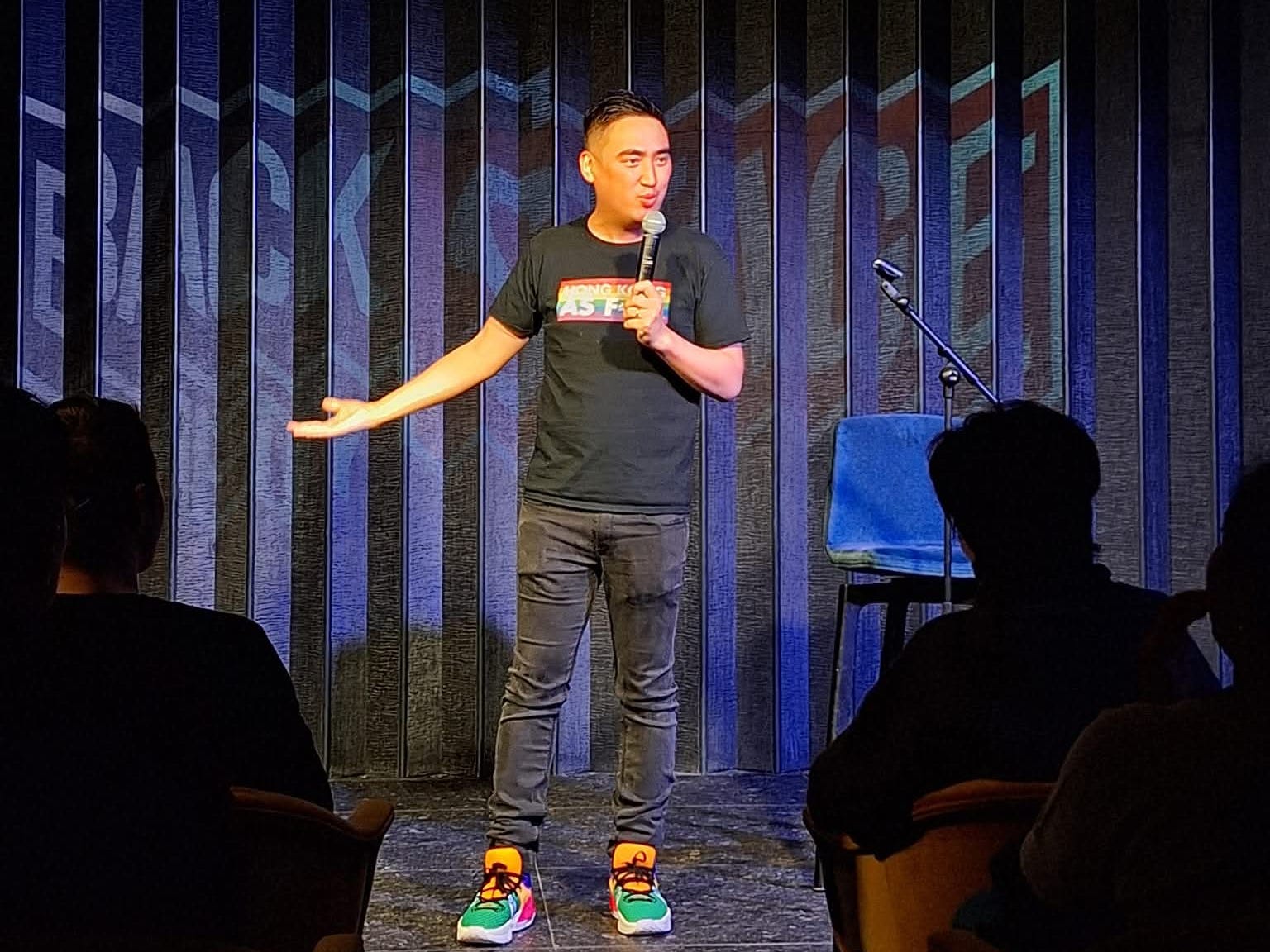 Garron Chiu on stage doing stand-up comedy in Hong Kong.
