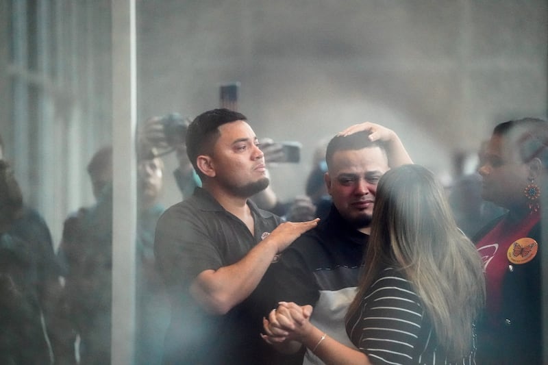 Abrego Garcia holding Vasquez Sura's hand as he prepared to go inside—he now faces deportation to Uganda.