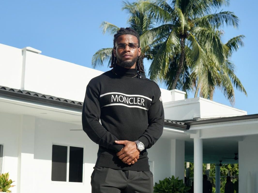 a man in a black outfit poses at a pool