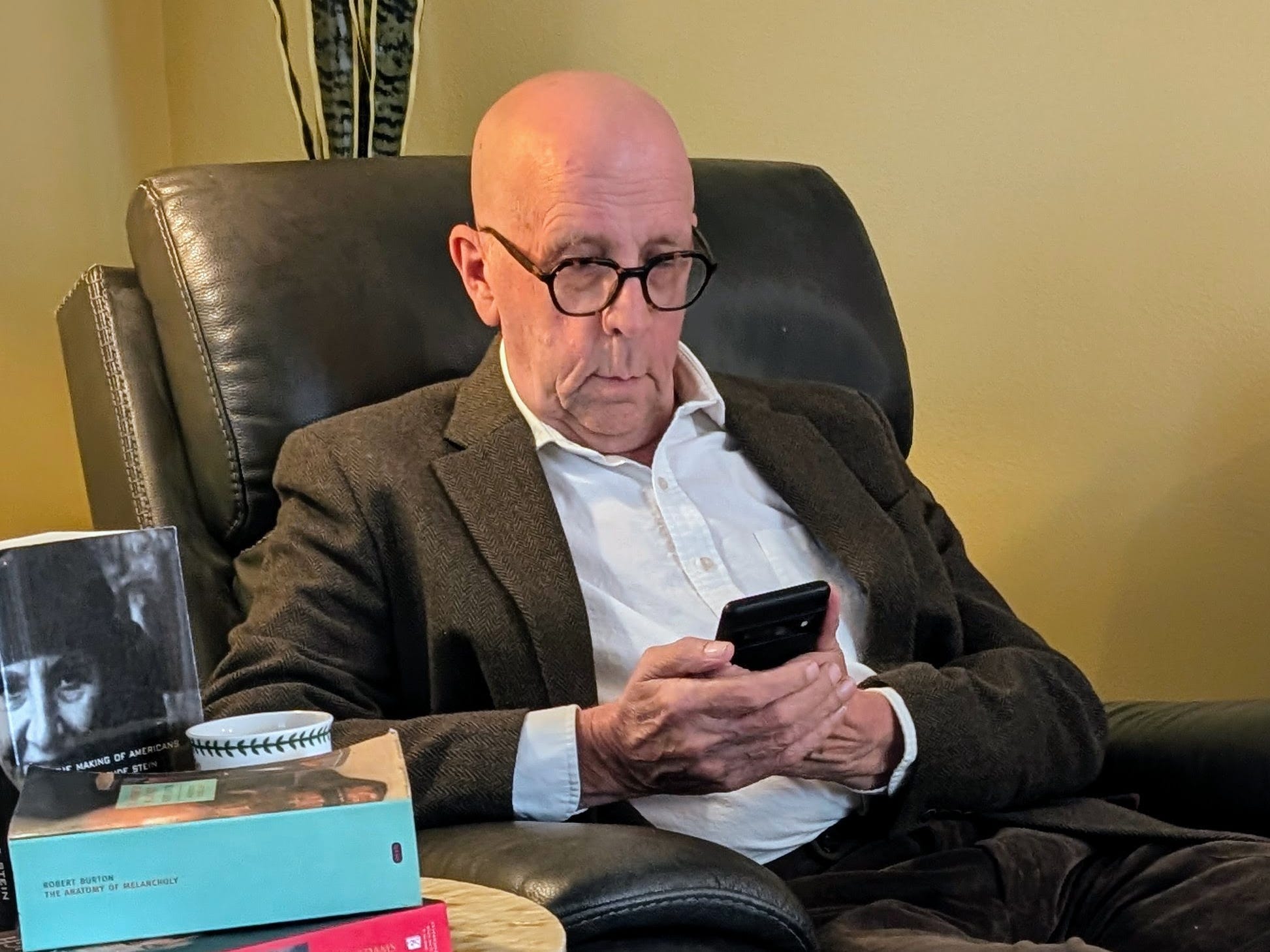 Orrin Onken in a chair looking at his phone
