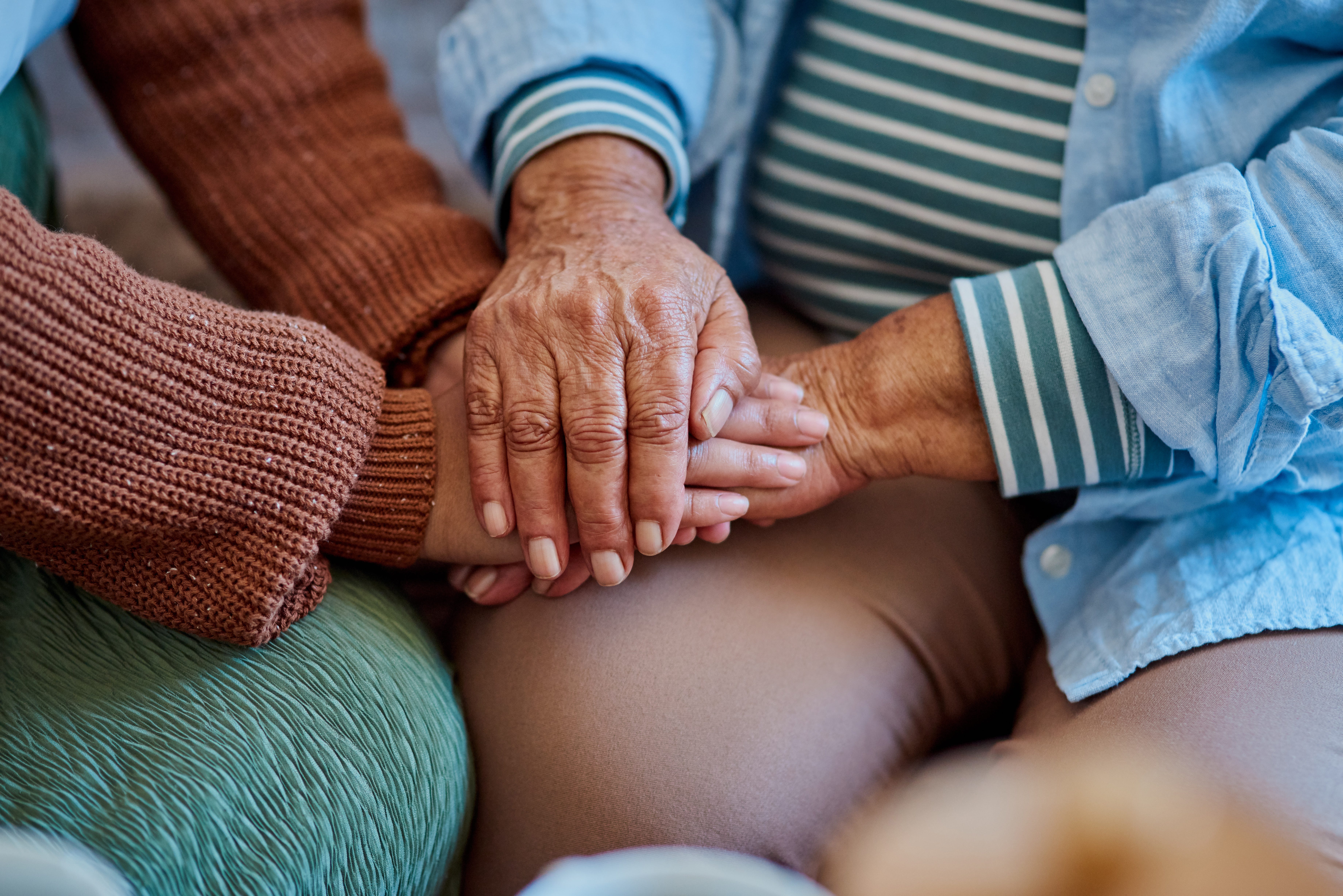 A mom and daughter hold hands.