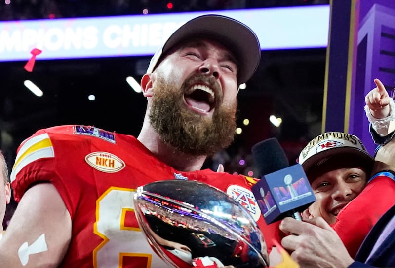 Travis Kelce holds the trophy next to Kansas City Chiefs' quarterback Patrick Mahomes as they celebrate winning Super Bowl LVIII