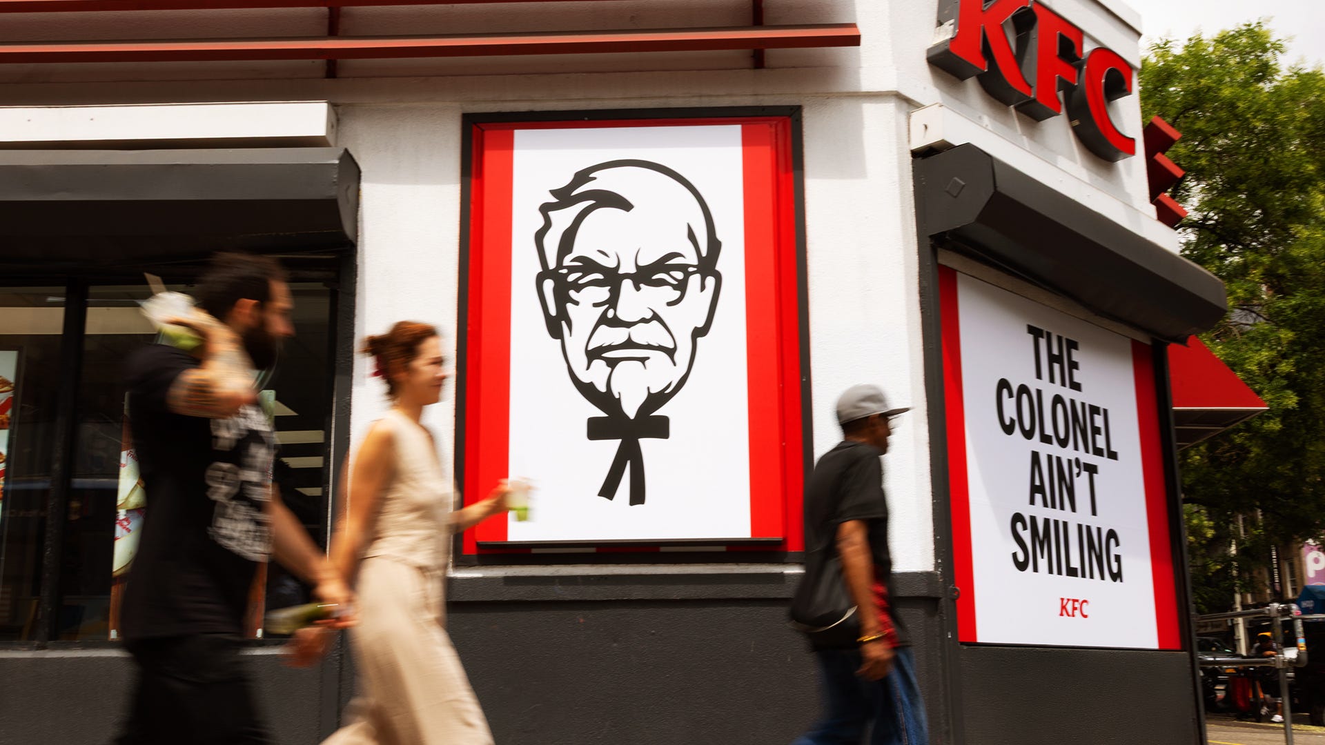 Customers walk by the outside a KFC restaurant.