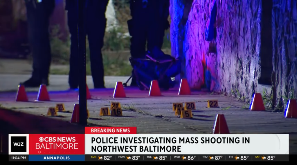 Evidence markers are placed on the ground at the scene where six people were wounded in a shooting in Baltimore, Maryland on Aug. 9, 2025.