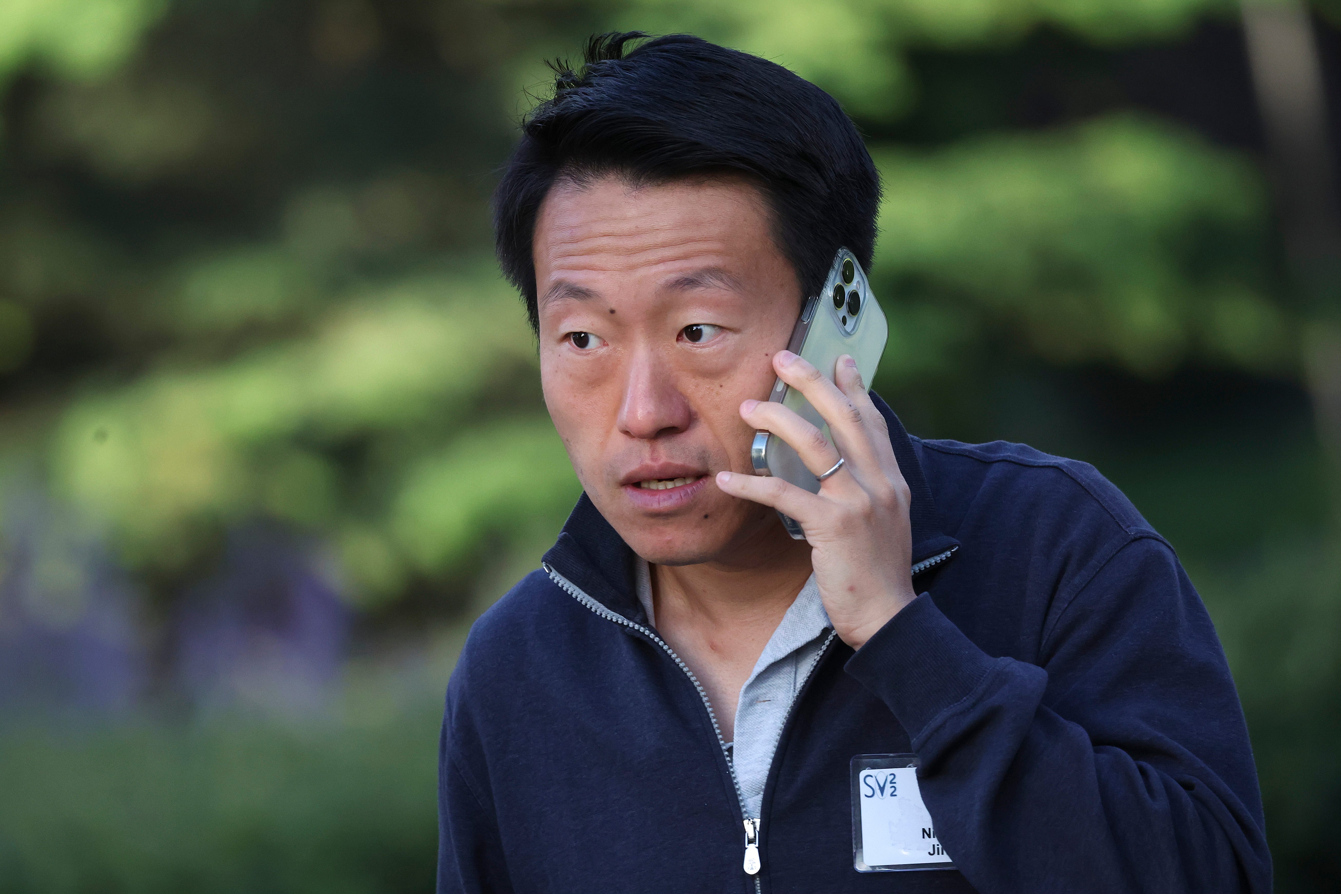 Ning Jin speaks outside on his cell phone