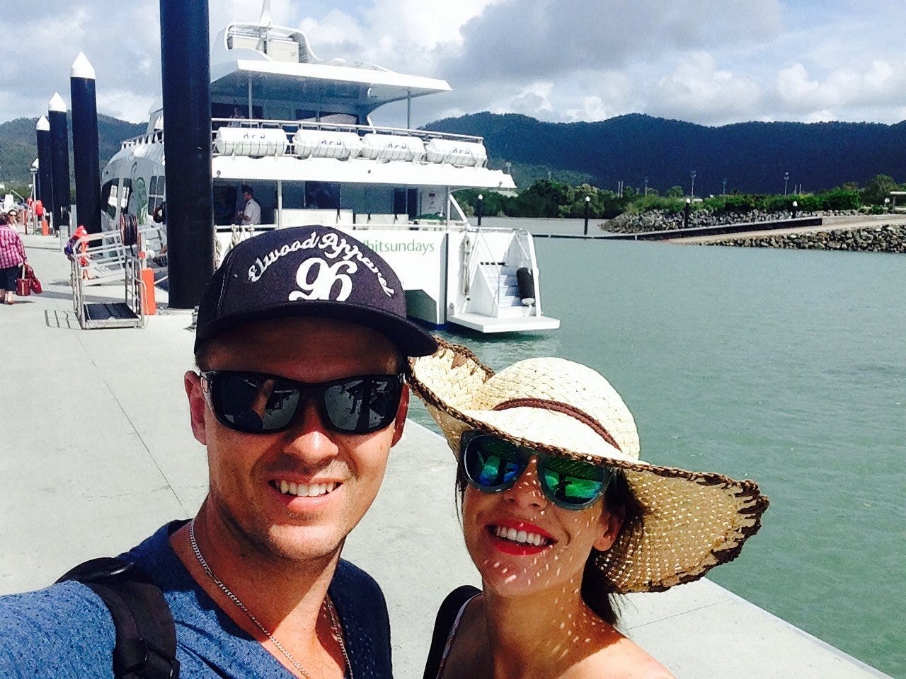 The author and her husband in front of a boat on a sunny day.