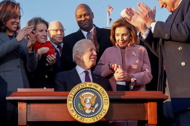  U.S. President Joe Biden celebrates with lawmakers including then-House Speaker Nancy Pelosi