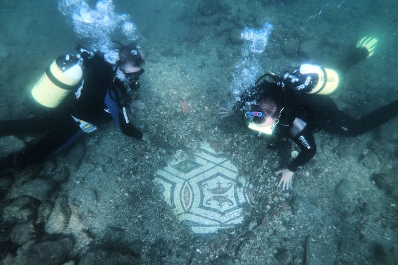Recreational divers looking at a mosaic