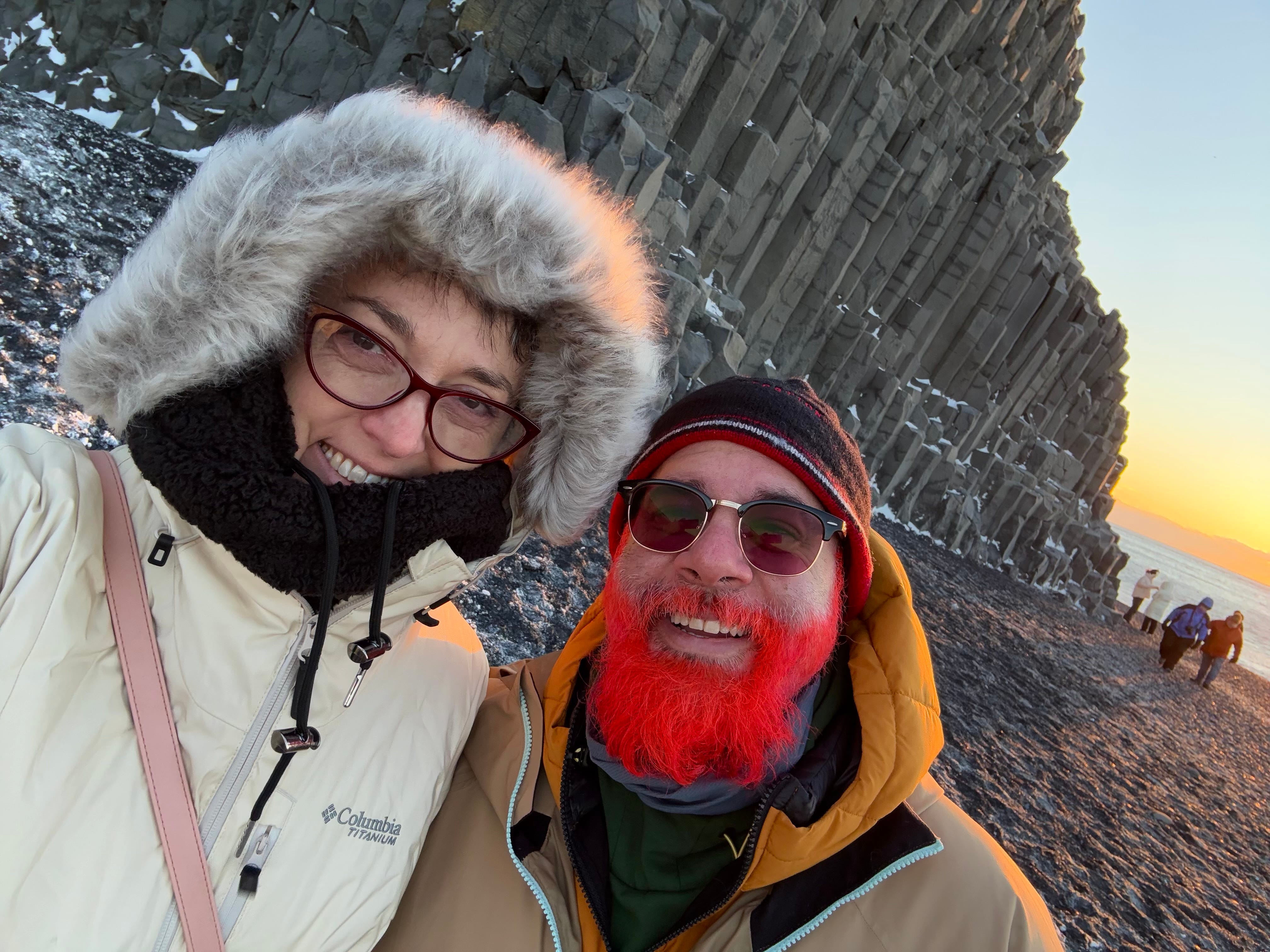 husband and wife taking a selfie with sunset in background