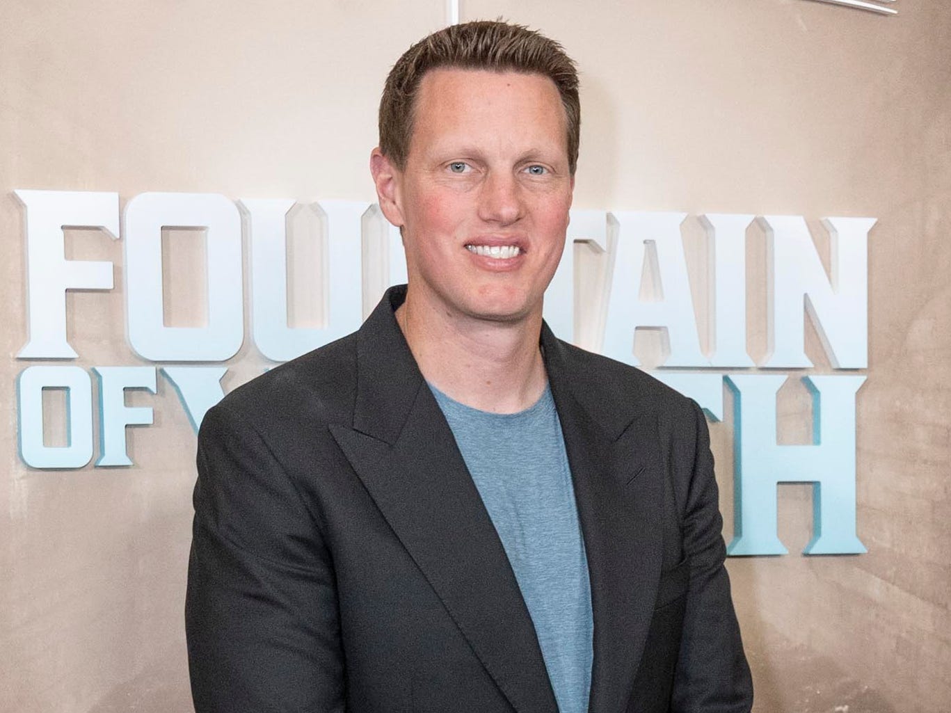 David Ellison stands in front of "Fountain of Youth" poster