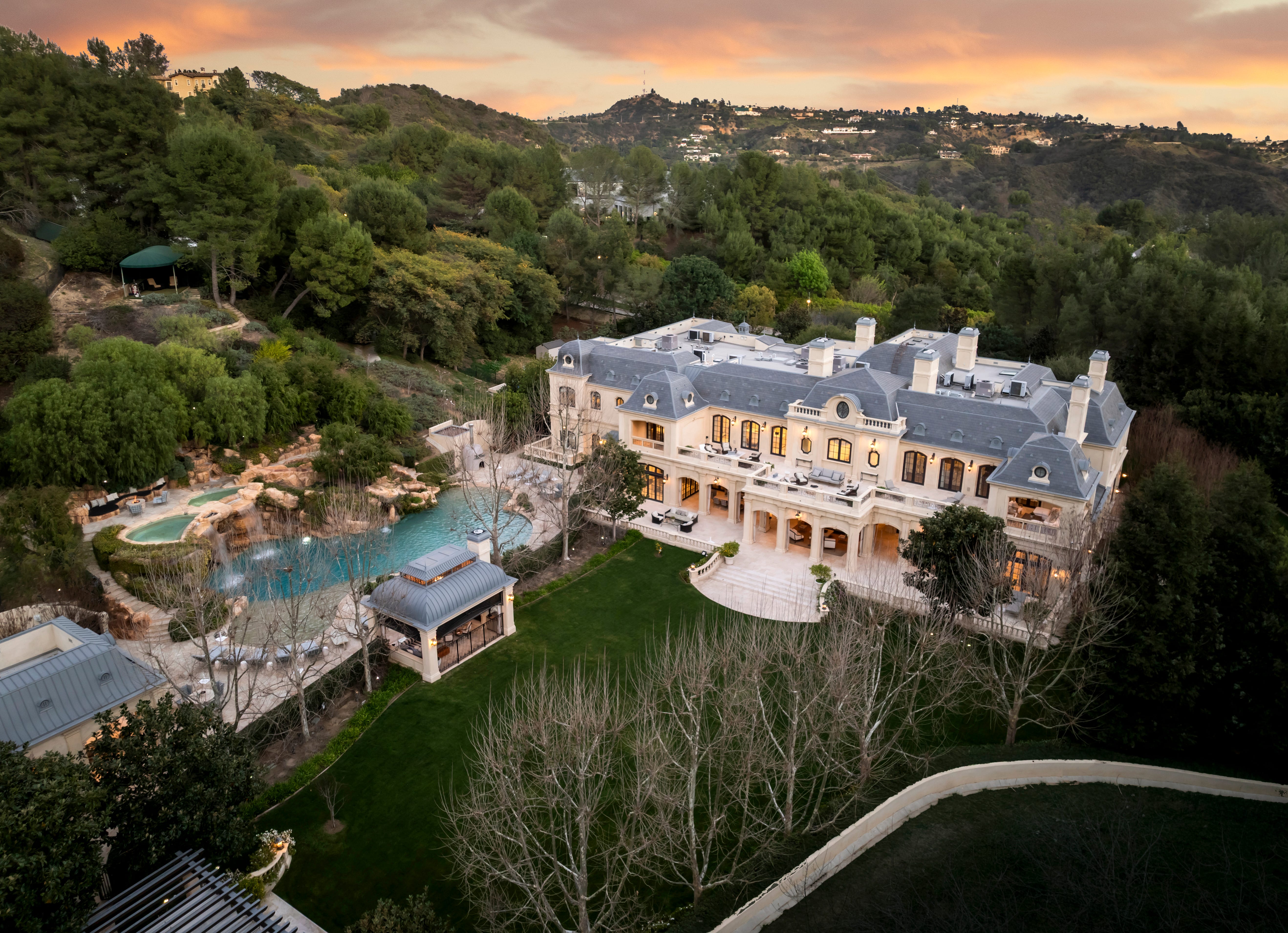 An overview of the backyard of a luxurious mansion, featuring its pool.