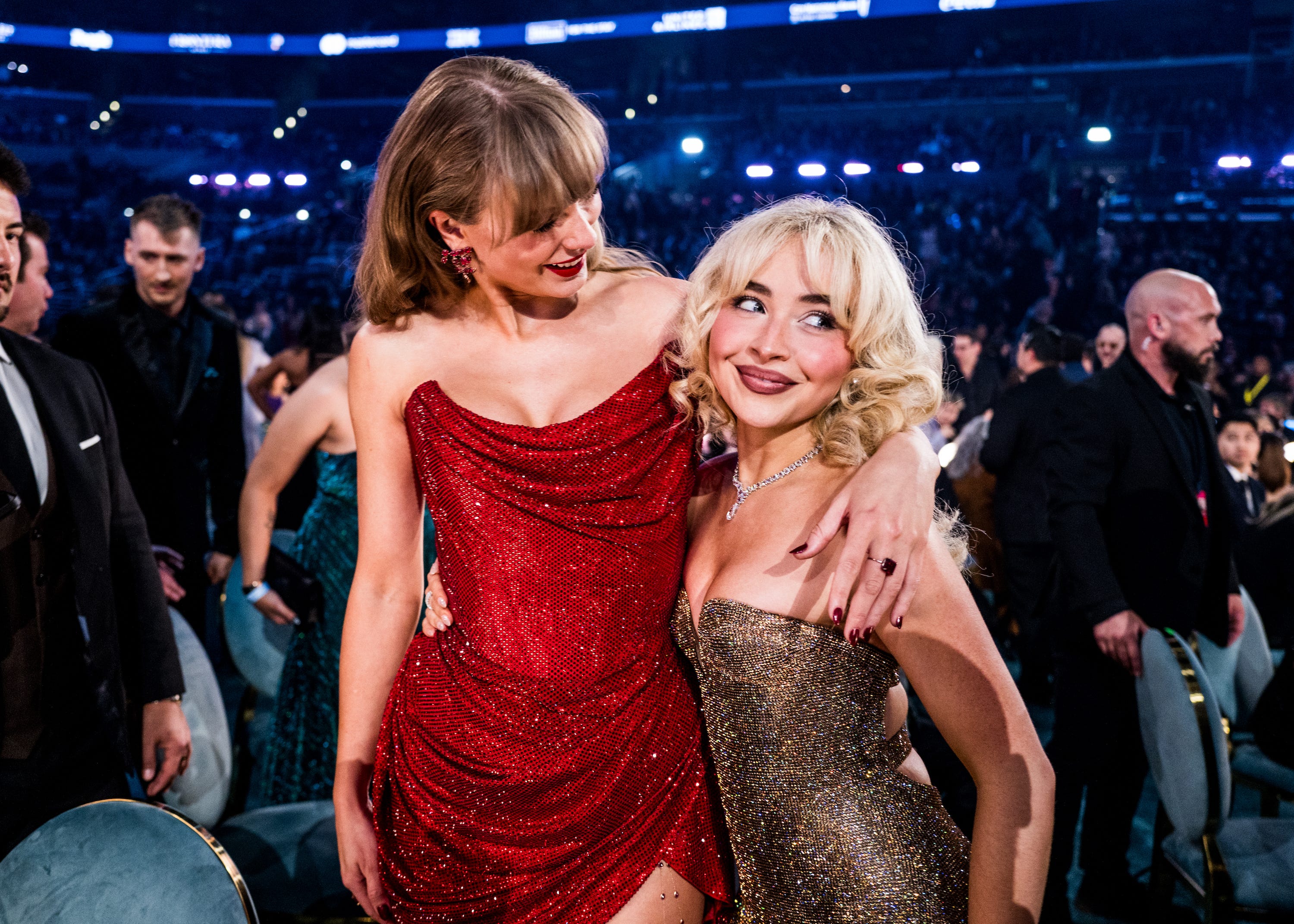Taylor Swift and Sabrina Carpenter with their arms round each other in the audience of the Grammys.