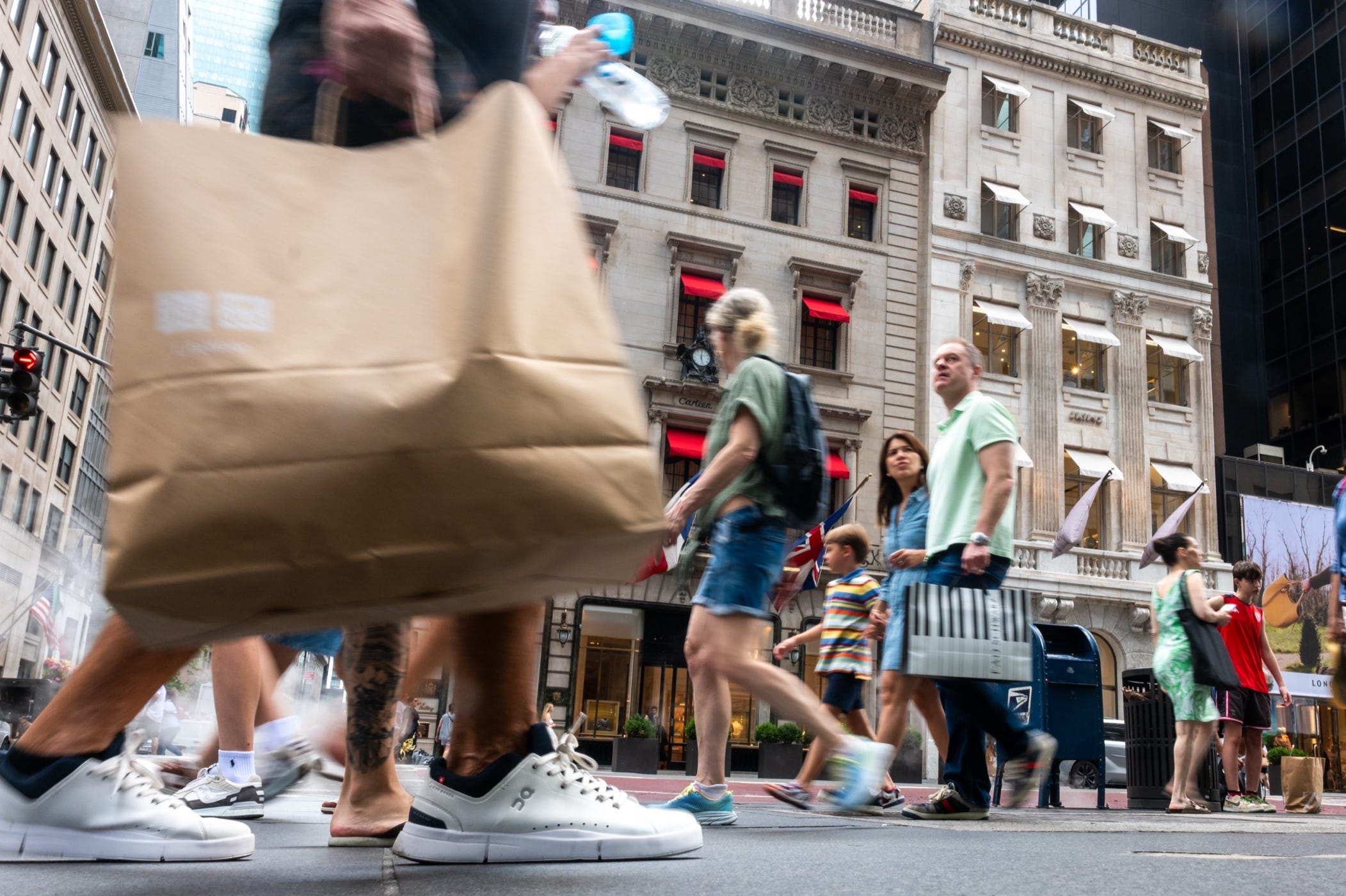 People walk in a shopping district along 5th Avenue in Manhattan.