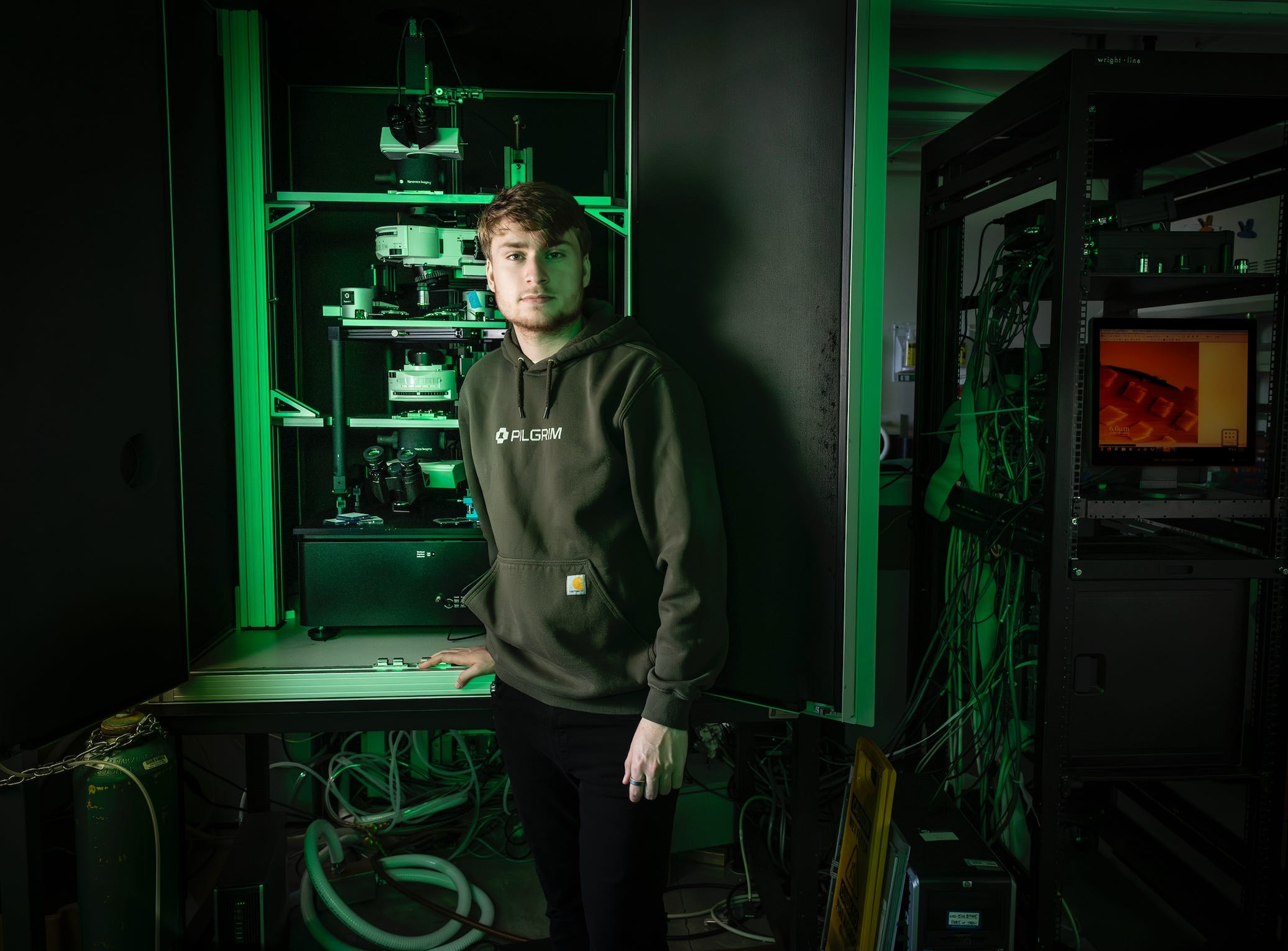Pilgrim founder Jake Adler posing with lab equipment wearing a black hoodie.