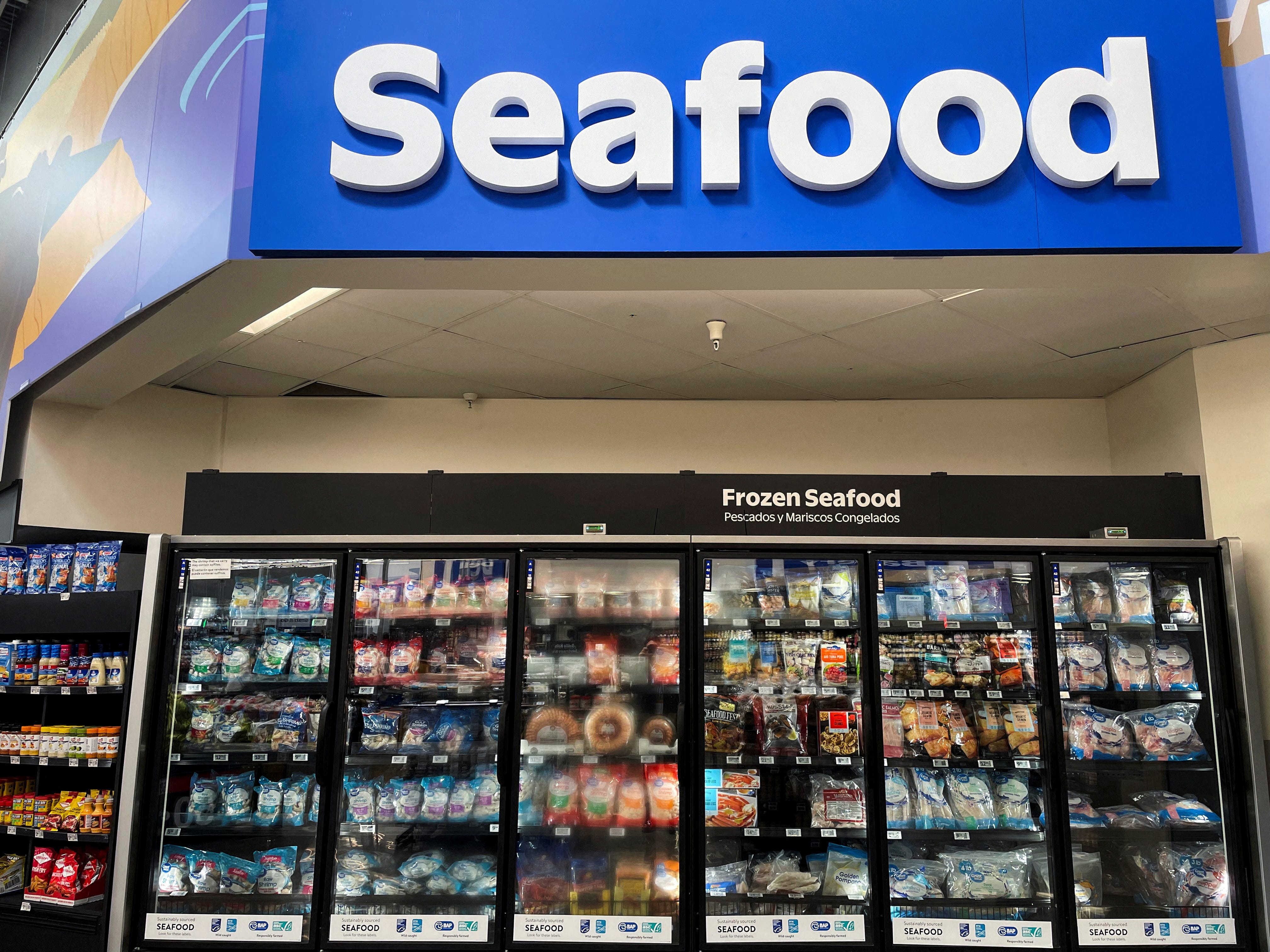 Coolers stocked with chilled and frozen products are displayed at the seafood section in Walmart Supercenter in Grapevine, Texas