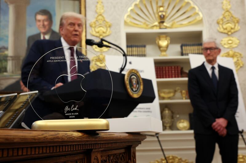 WASHINGTON, DC - AUGUST 06: U.S. President Donald Trump speaks behind an engraved glass disc gifted to him by Apple CEO Tim Cook (R) during an event in the Oval Office of the White House on August 6, 2025 in Washington, DC. Apple Inc. announced a $100 billion investment in manufacturing facilities in the U.S., on top of an announcement in February committing over the next four years to a $500 billion investment in the U.S. economy and the addition of 20,000 new jobs. (Photo by Win McNamee/Getty Images)
