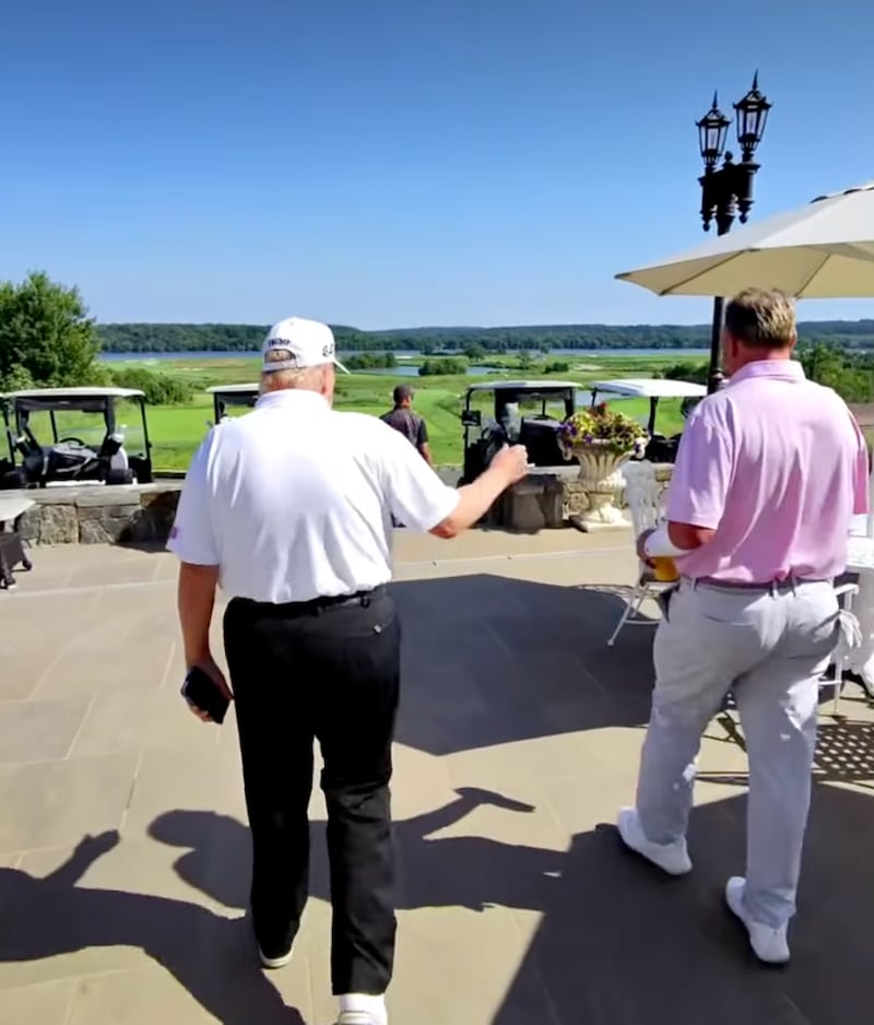 Trump walks with Roger Clemens on Saturday.