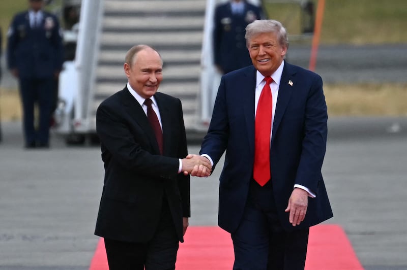 US President Donald Trump (R) shakes hands with greets Russian President Vladimir Putin on the tarmac after they arrived at Joint Base Elmendorf-Richardson in Anchorage, Alaska, on August 15, 2025.