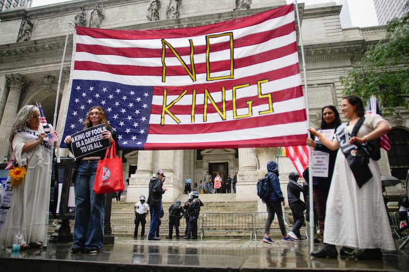 Demonstrators hold a banner featuring a U.S. flag displayed upside down with the words "No Kings" written across it during the "No Kings Day" protest.