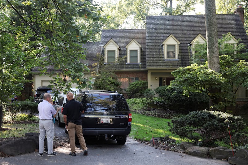 People stand outside the home of the former White House national security adviser John Bolton as it is searched by FBI members, in Bethesda, MD on August 22, 2025.