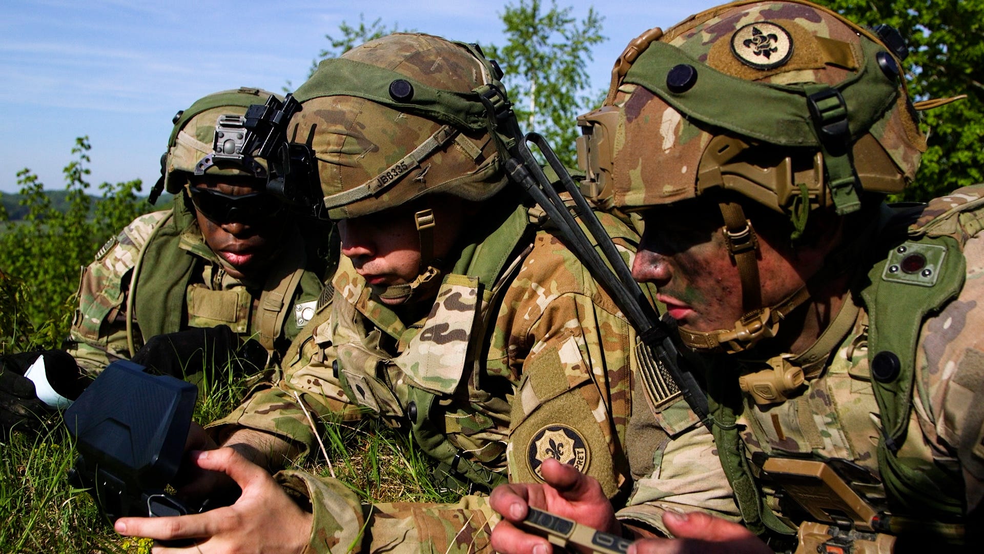 US Army soldiers looking at a handheld device.