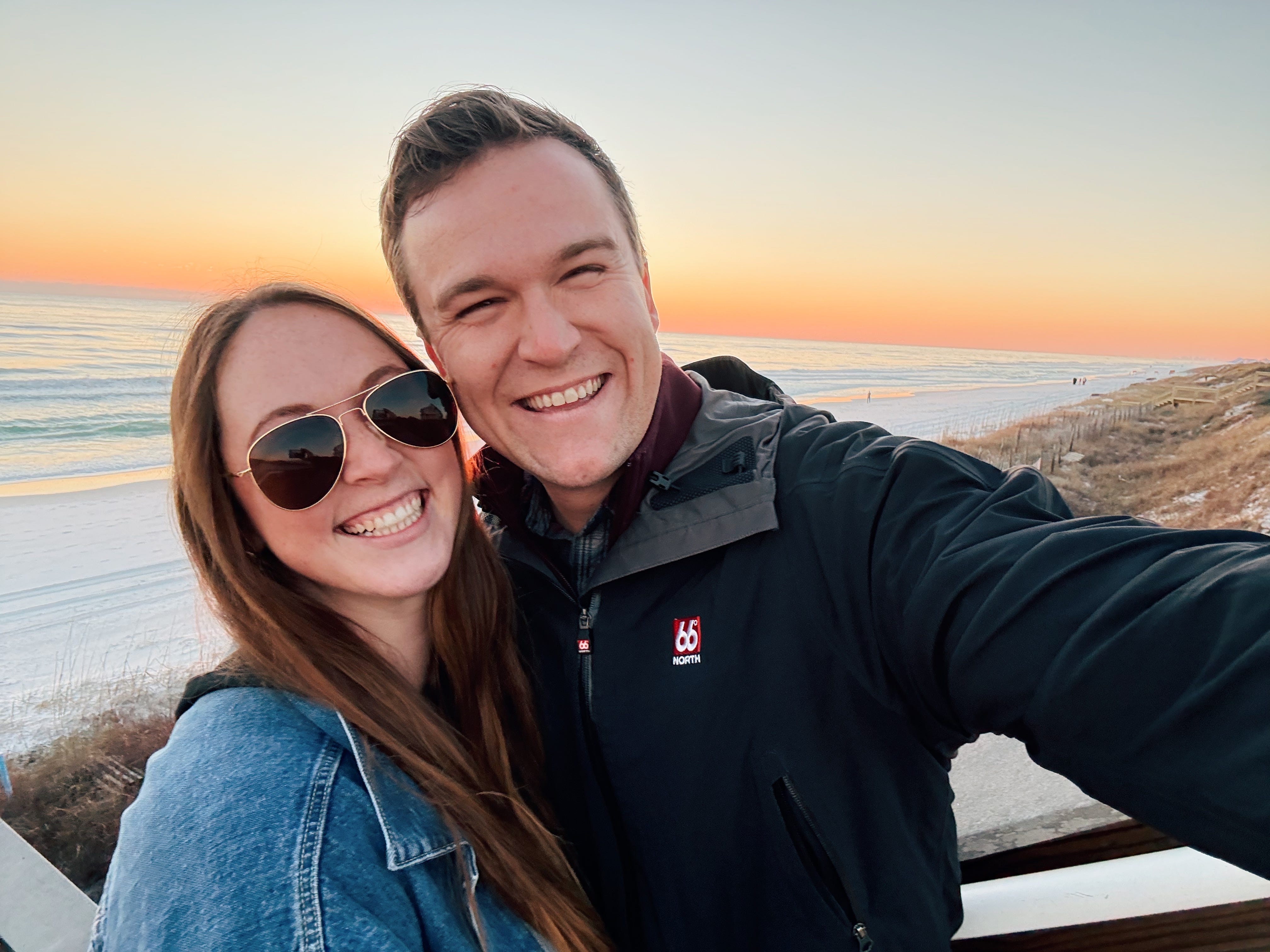 Allie Hubers and husband smiling at sunset in front of beach in Florida