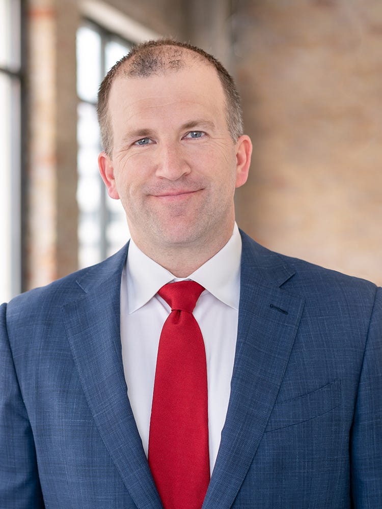 Michael Fiddelke wering a suit looking at the camera