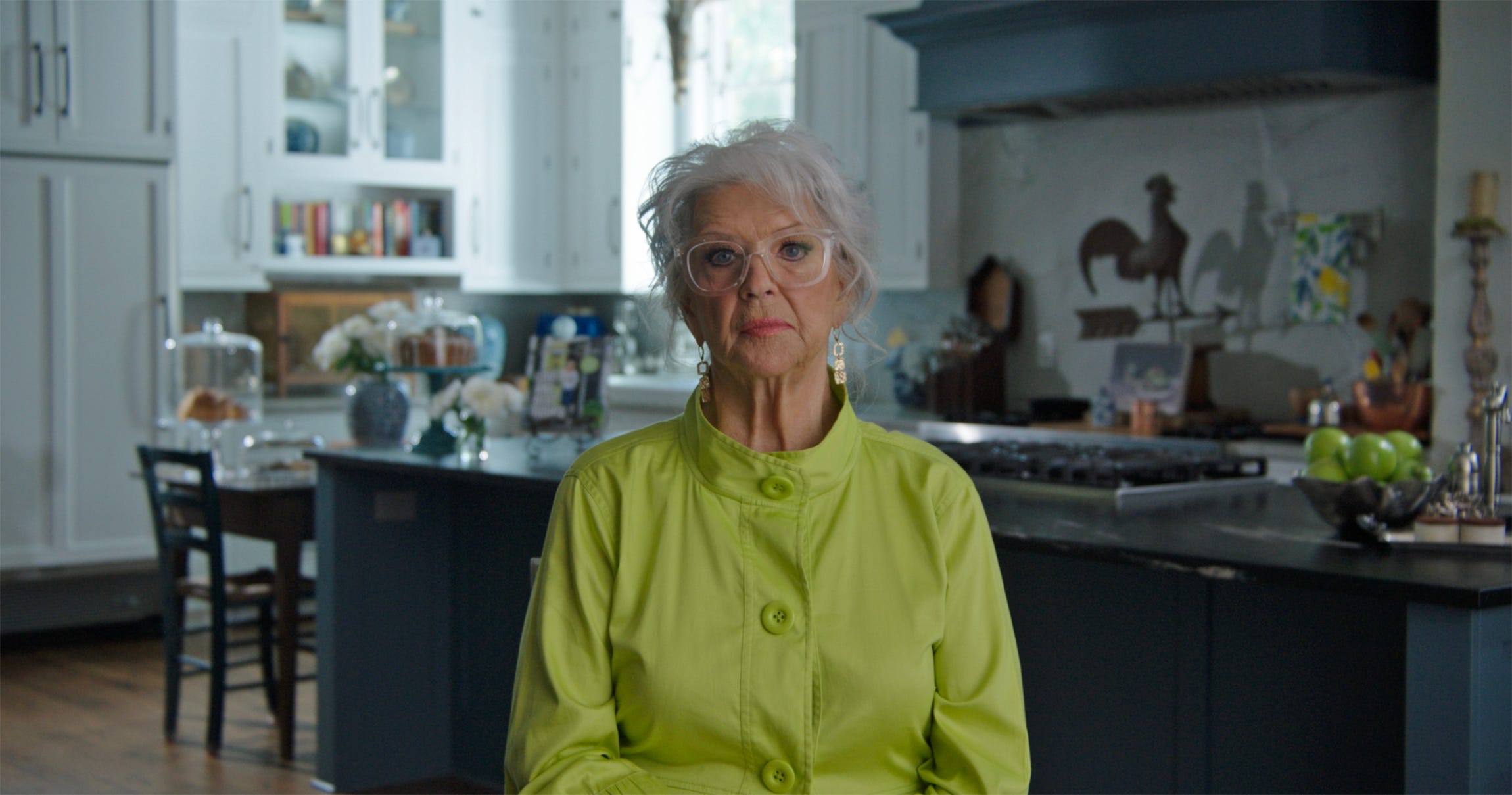 Paula Deen sitting in her kitchen