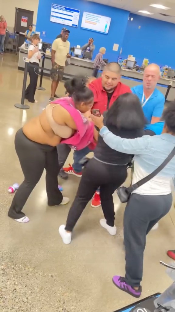  a woman in a pink shirt is seen savagely raining punches down on him, as another suspect starts to viciously stomp on him.