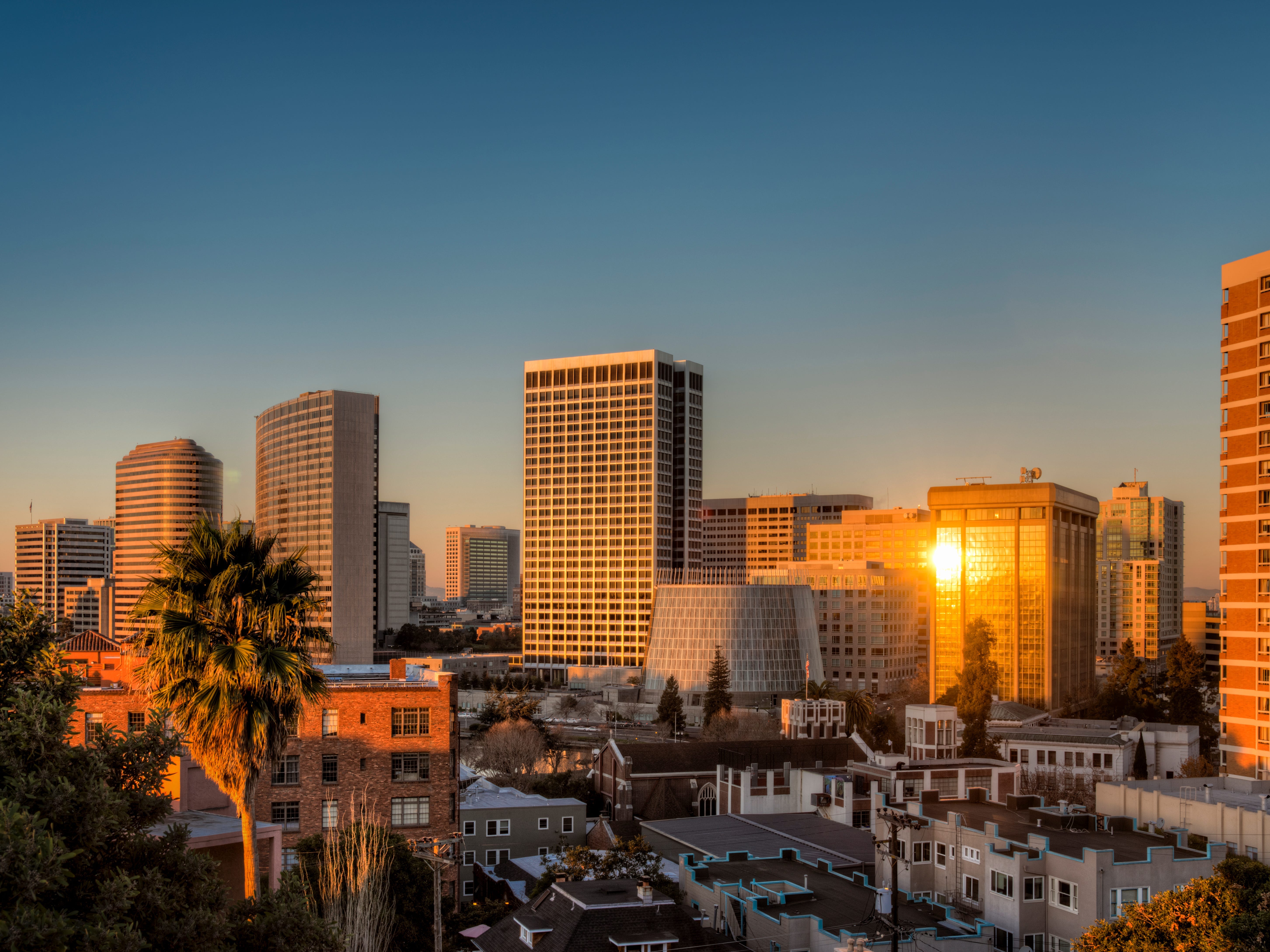 The sun rising and reflecting on buildings in downtown Oakland, California.