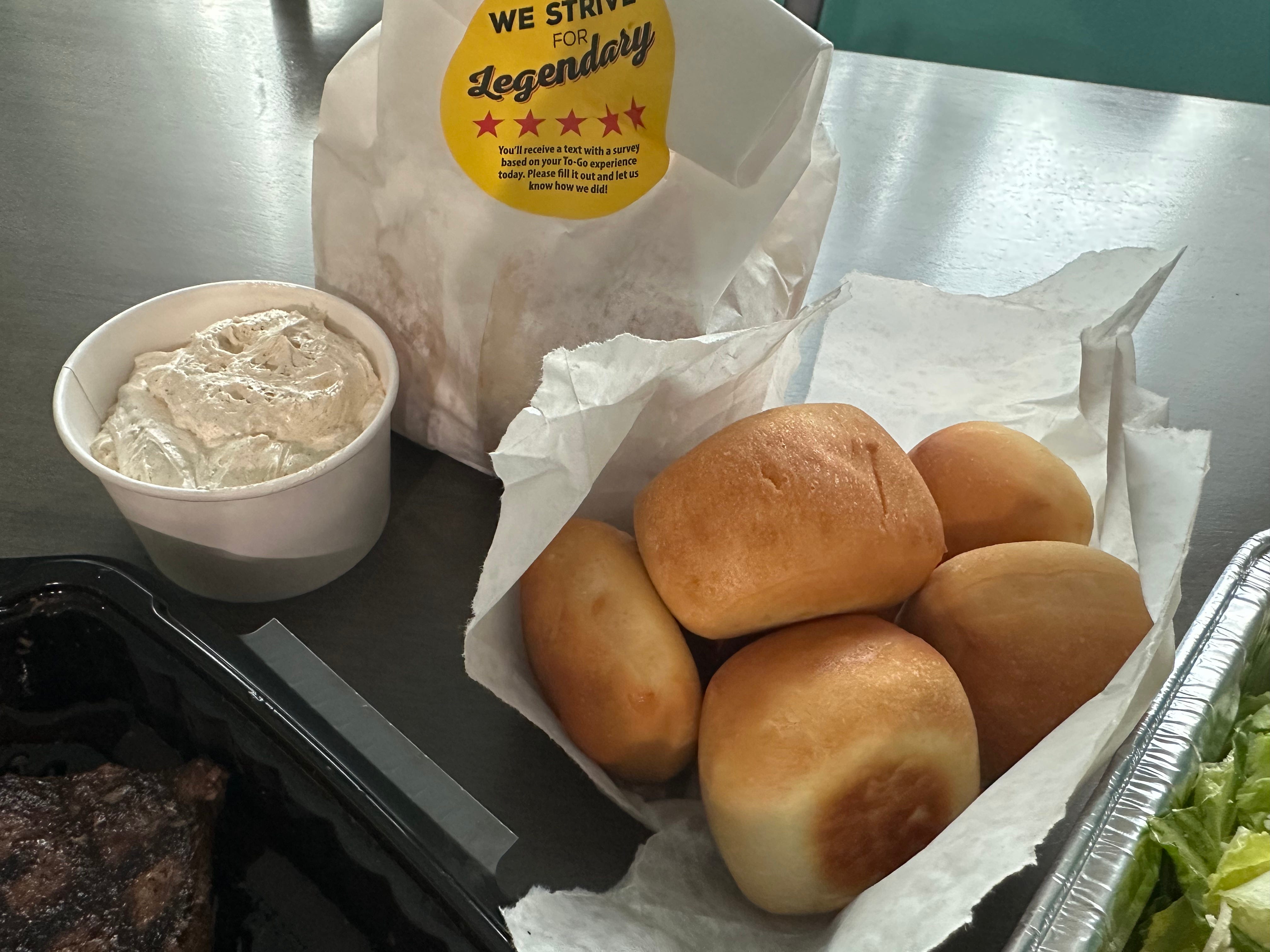 Texas Roadhouse rolls with container of cinnamon butter