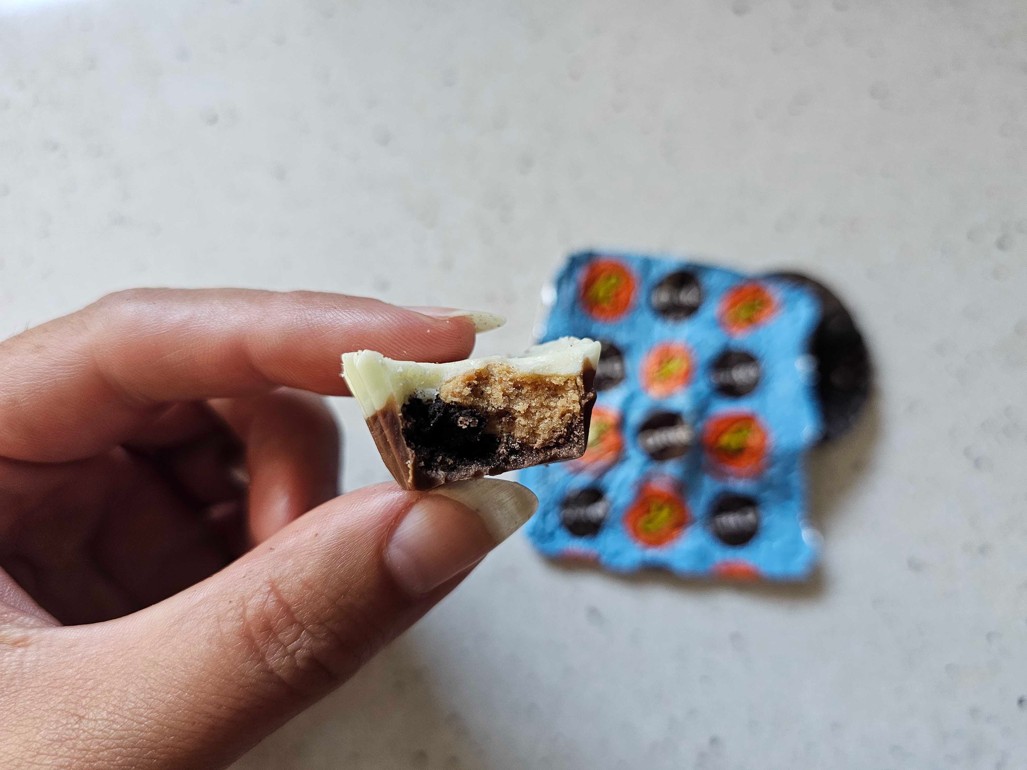 A close-up of a Reese's with Oreo cream with a bite taken from it.
