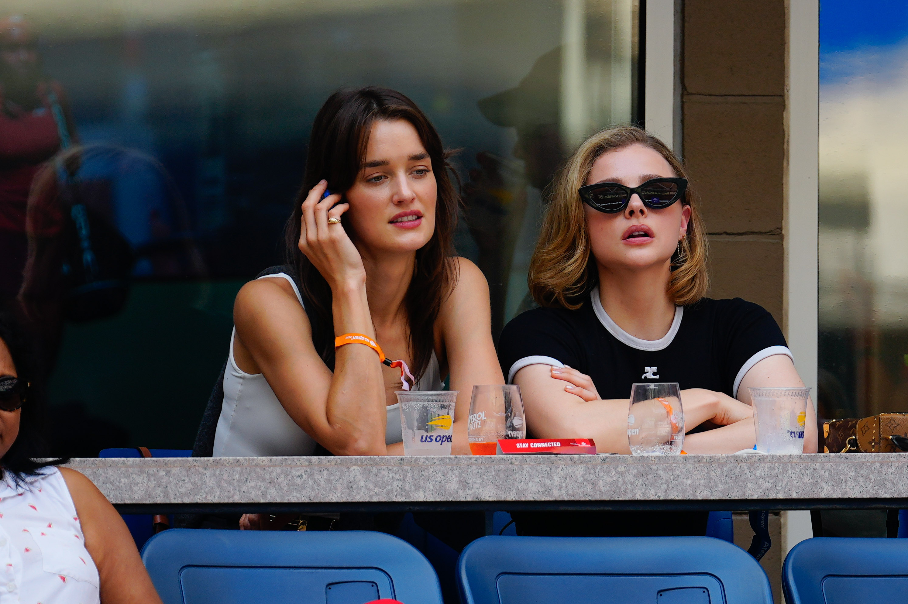 Chloe Grace Moretz and Kate Harrison sitting at an event. 